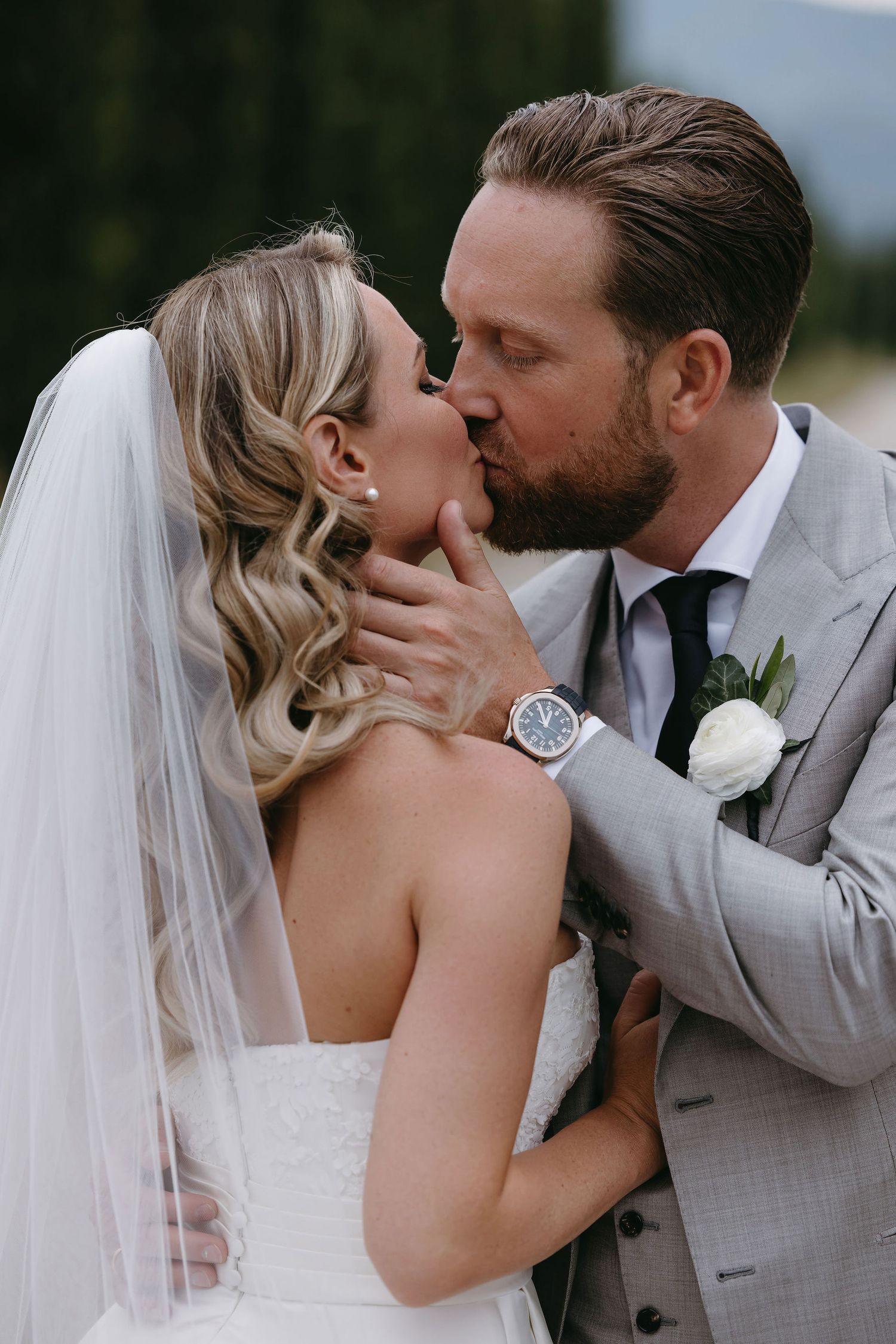 Romantic wedding moment captured under a flowing white veil.