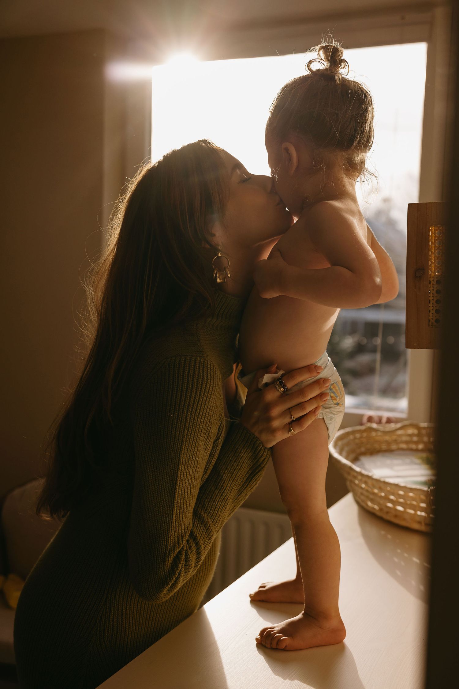 Warm sunlit scene with knit sweater and intimate moments by window.