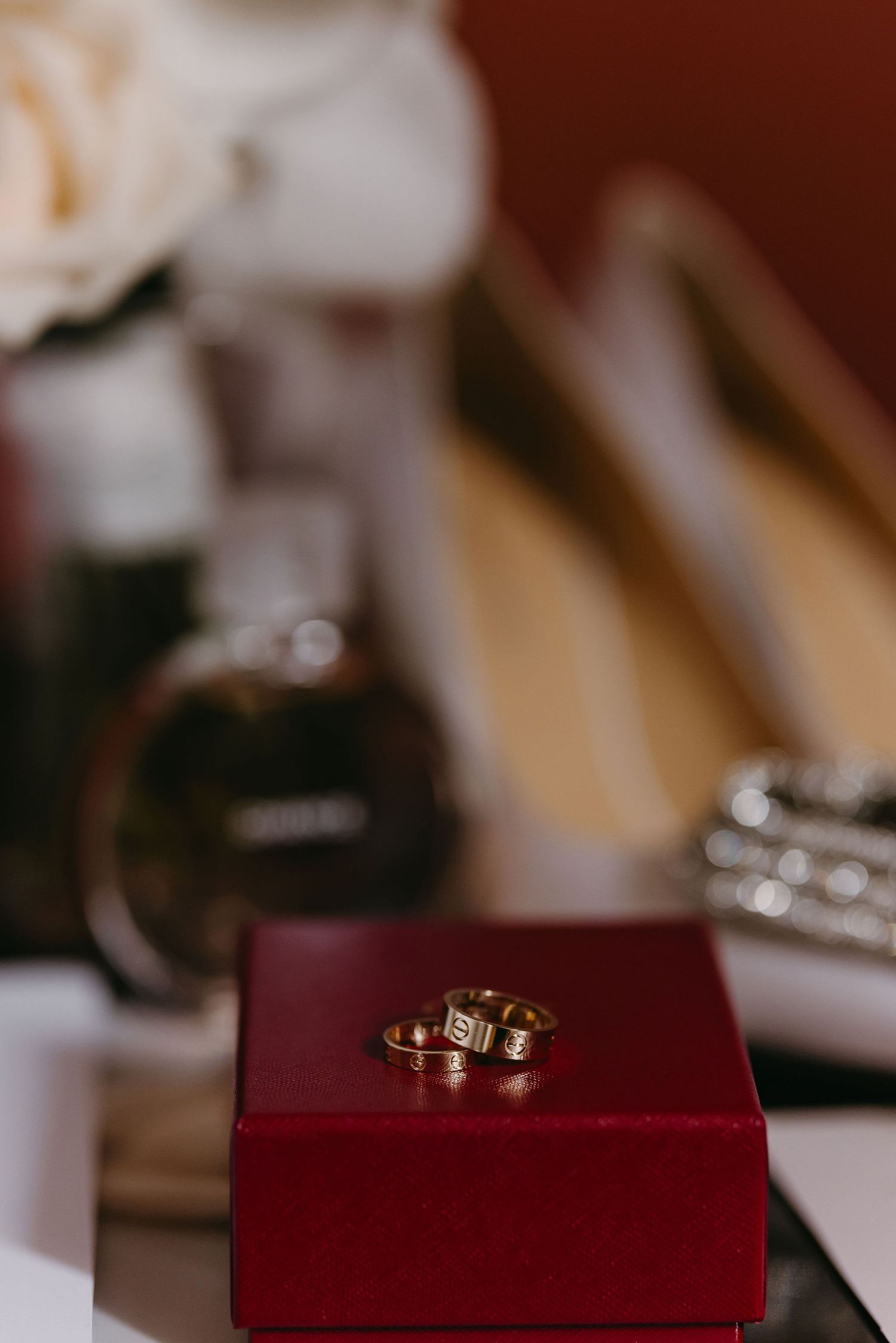 Wedding rings displayed on a burgundy velvet ring box.
