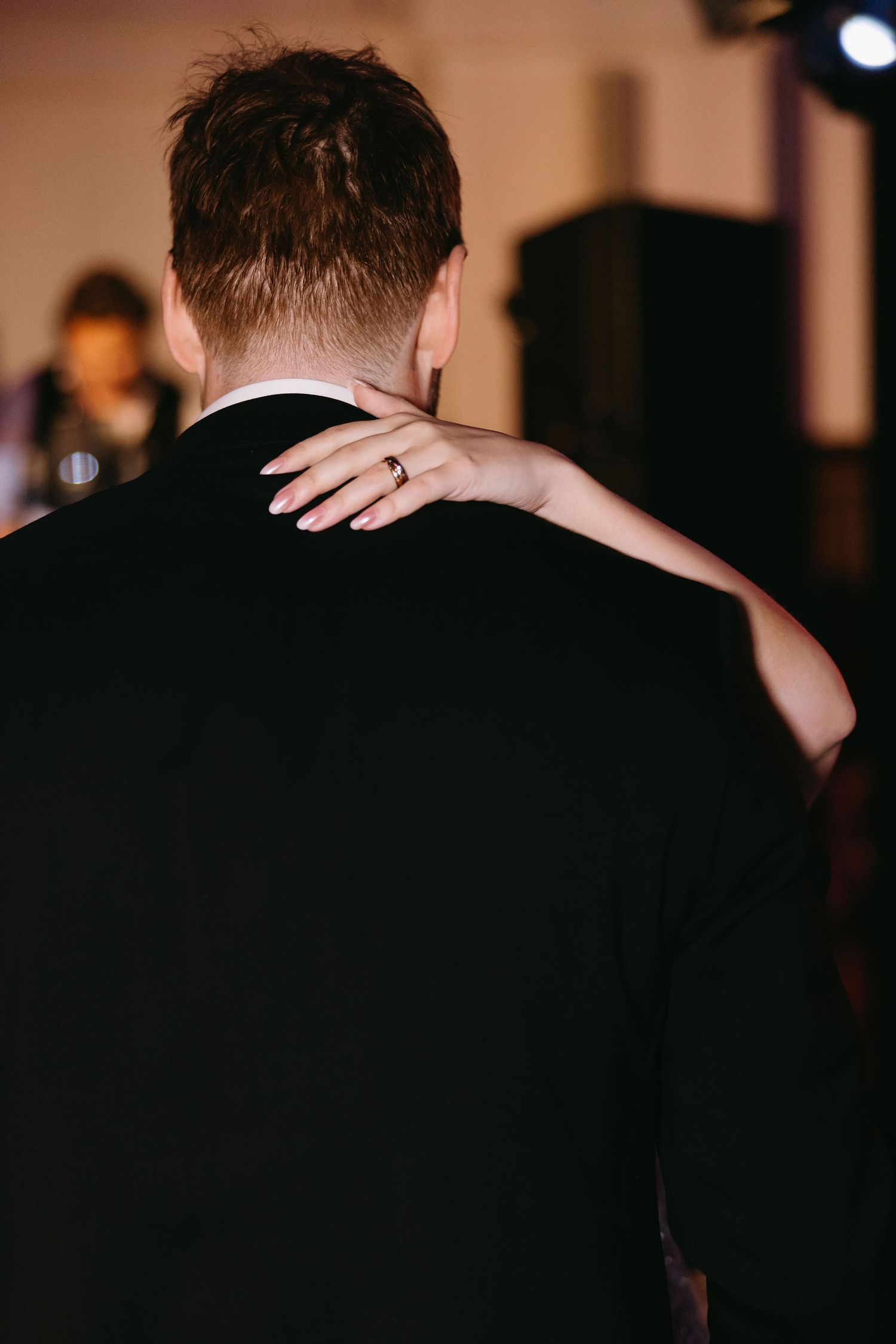 Dramatic silhouettes against dark background at formal event.