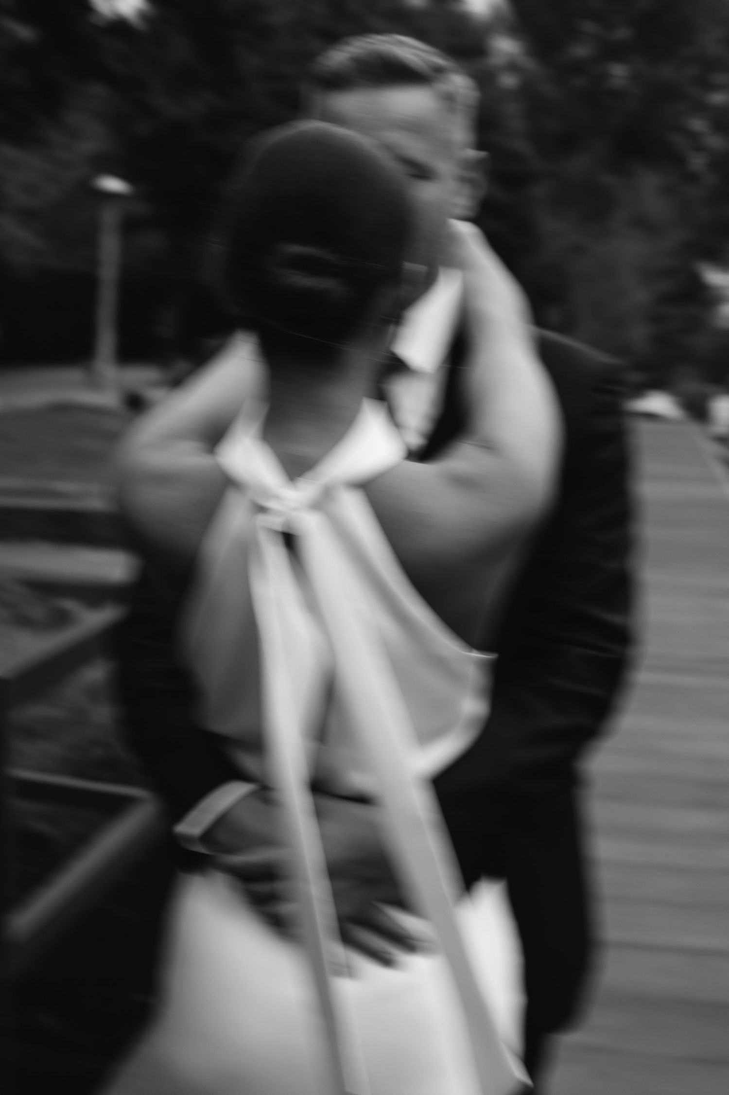 An artistic blurred black and white photograph captures an intimate moment between a couple on their wedding day.