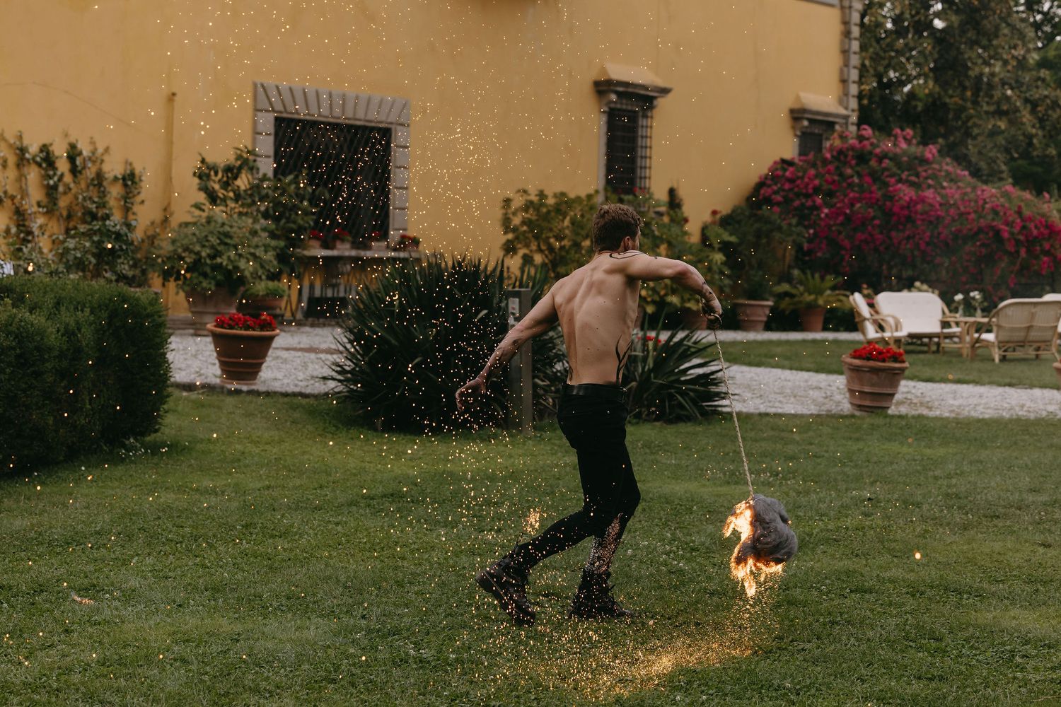 Someone running through a garden with a dog at an Italian villa.
