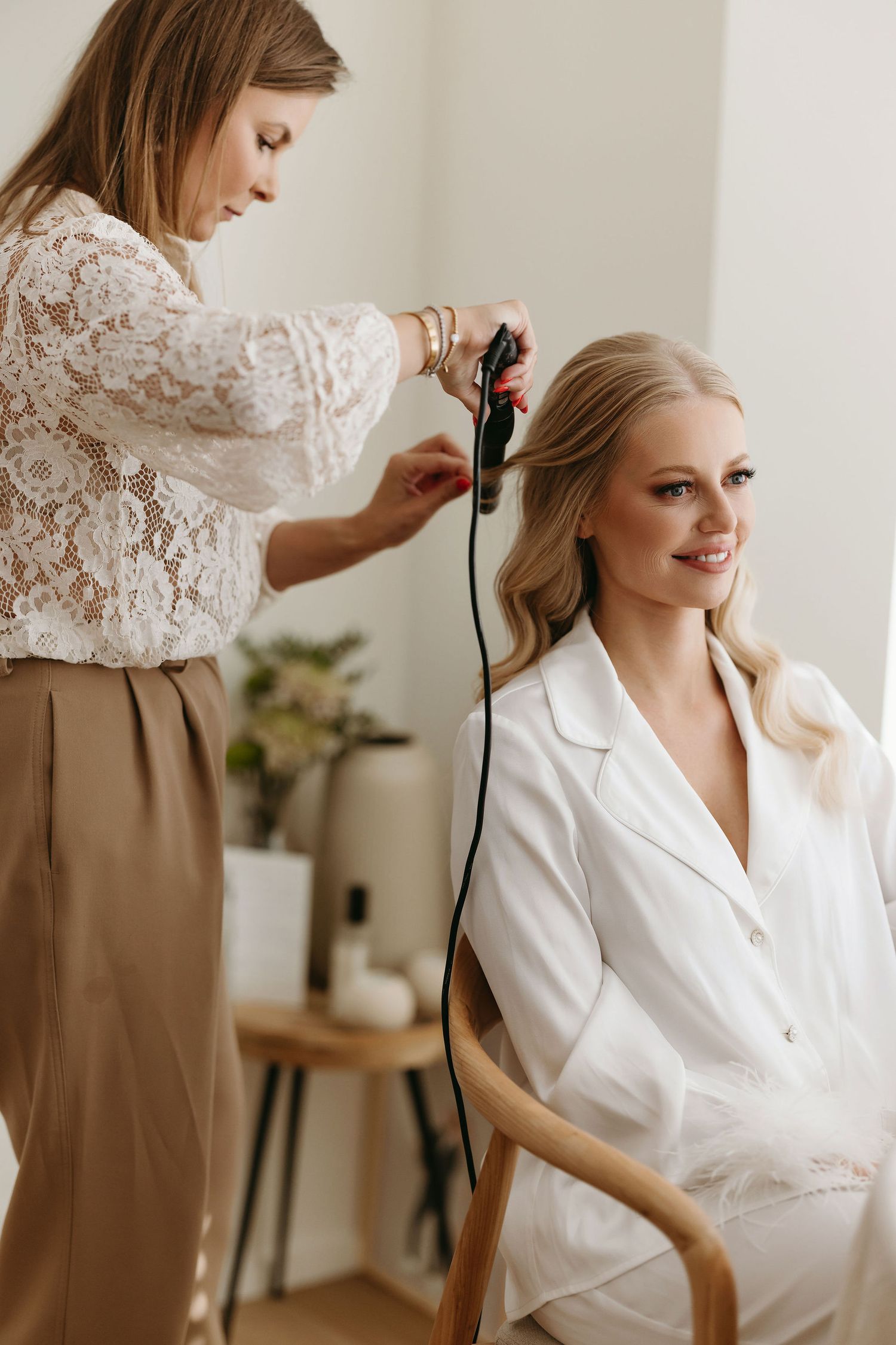 Getting ready scene with styling preparations on wedding morning in bright room.