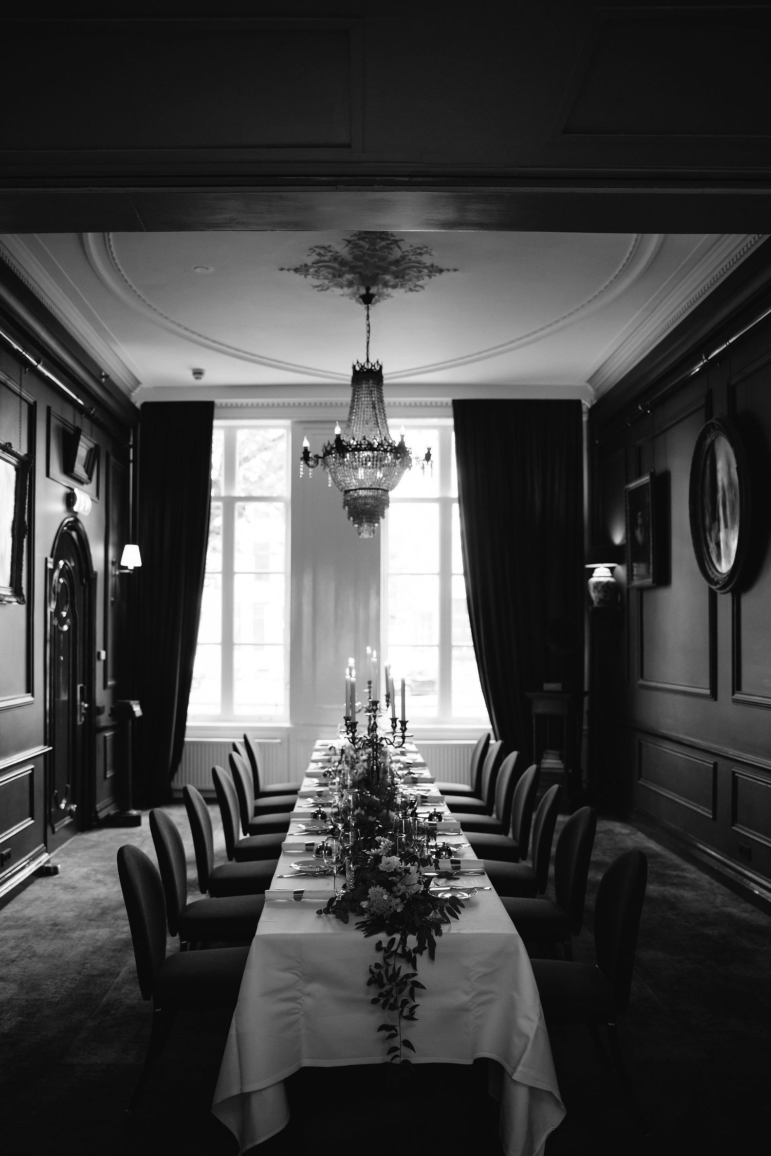 Moody dining room with dark walls set for an elegant wedding reception.