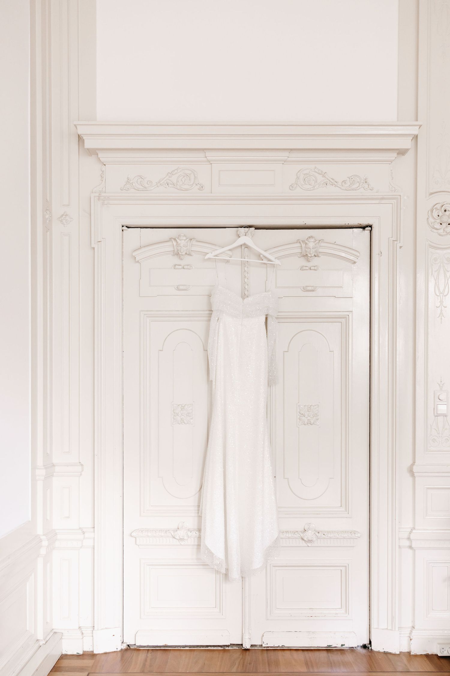 Elegant white interior room with ornate molding and paneled walls.