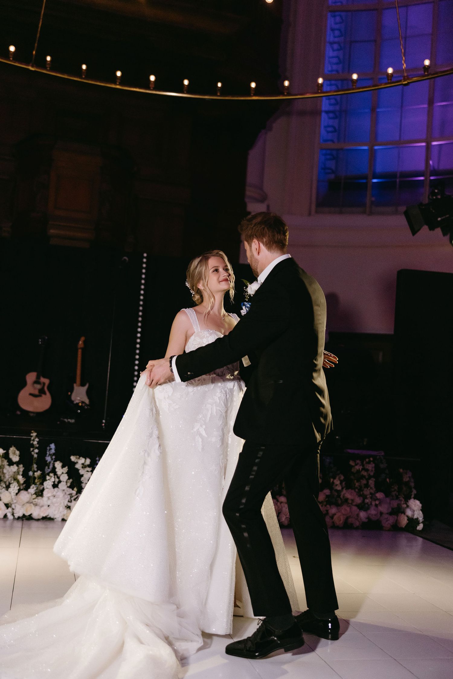 A romantic first dance sequence on an illuminated dance floor at an elegant wedding reception.