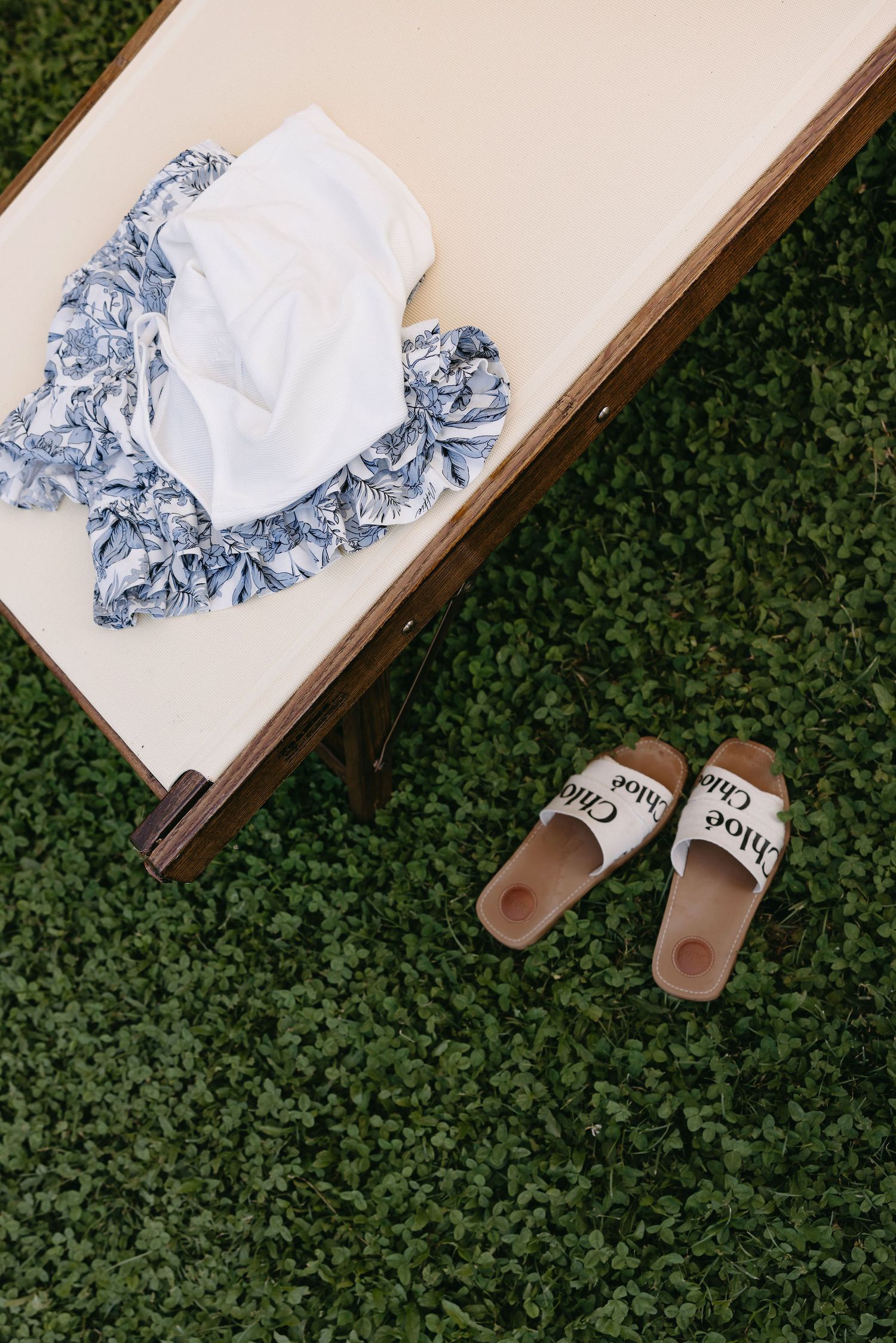 Blue and white patterned handkerchiefs displayed on a wooden surface against green foliage.