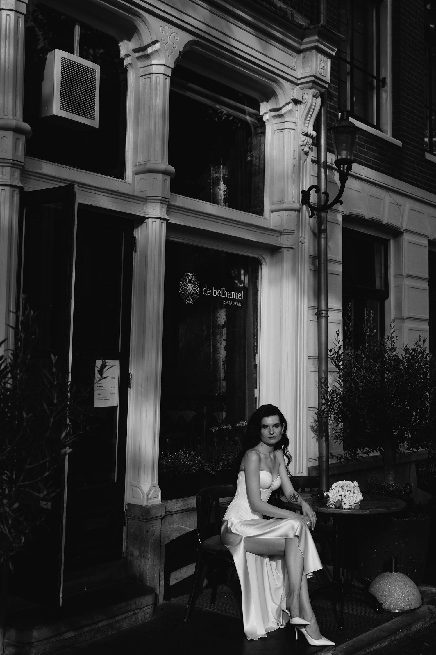 Four artsy black and white photos show a figure sitting on steps at night in a flowing dress or garment.