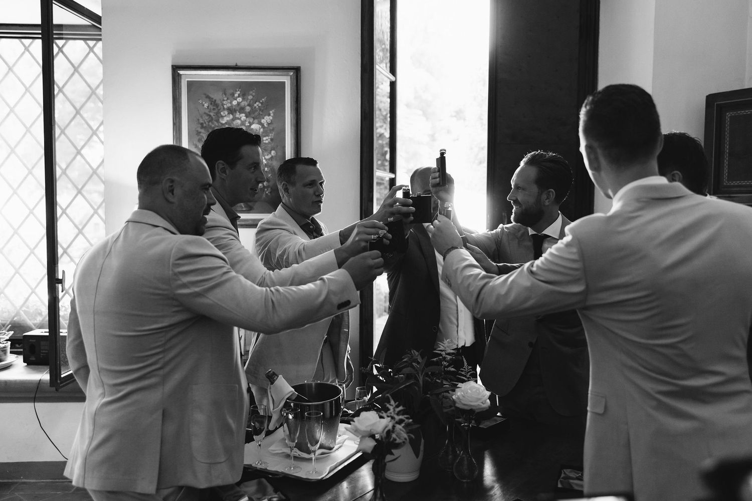 Black and white photo of preparation moments in an interior space with window light.