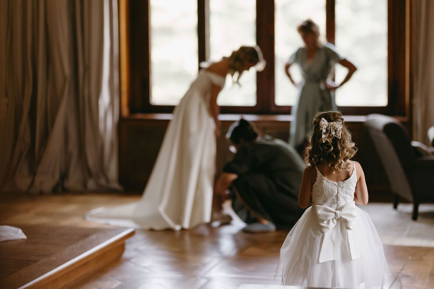 Wedding preparations in a sunlit bridal suite with flowing white gowns.