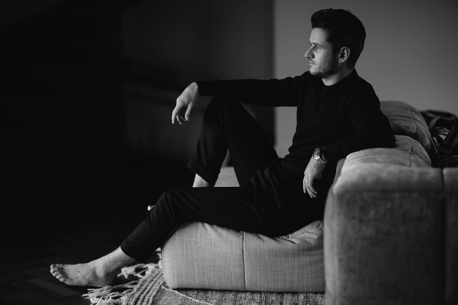 Moody black and white maternity session on comfortable indoor furniture.