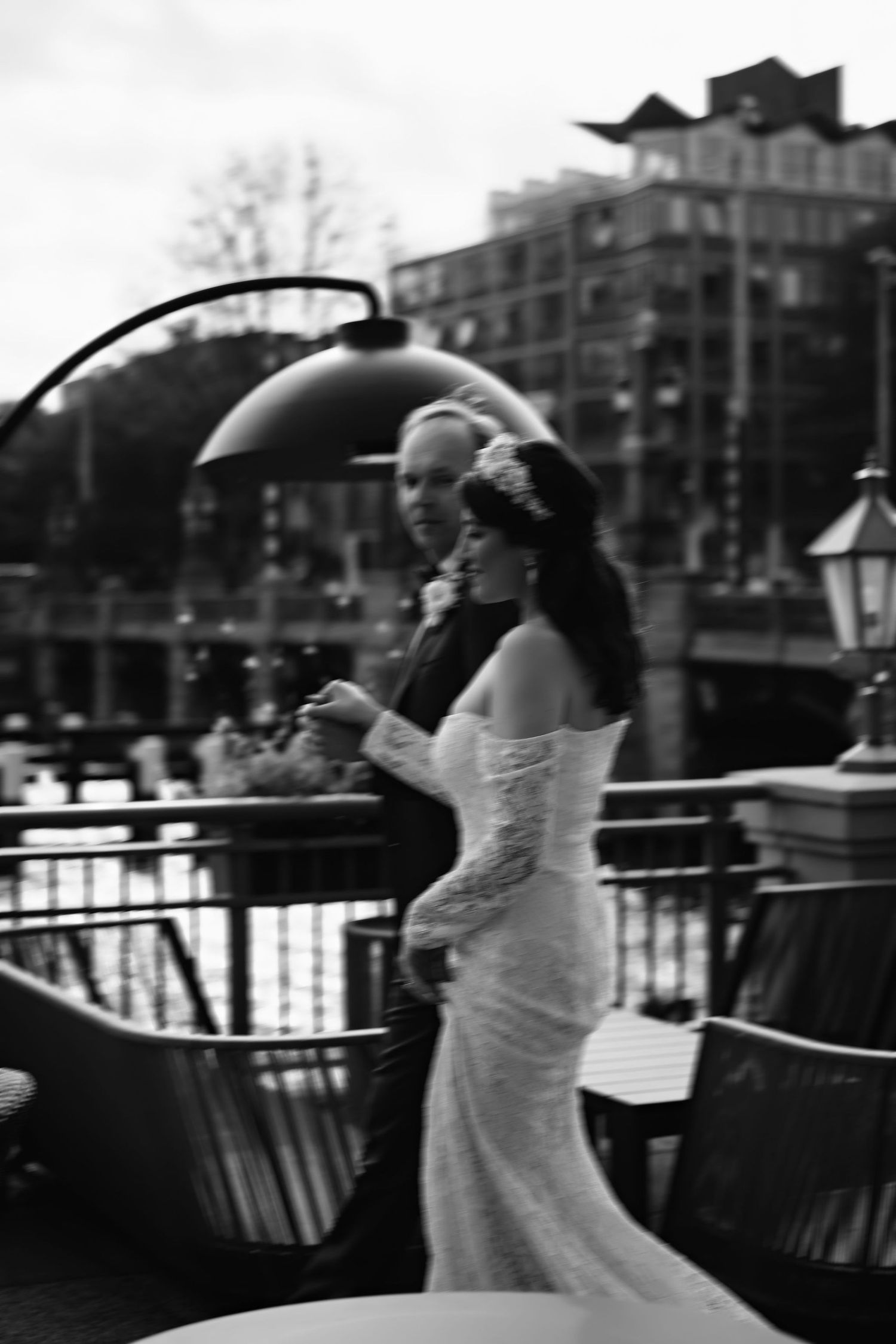Black and white wedding photography sequence showing bride with umbrella on urban waterfront.