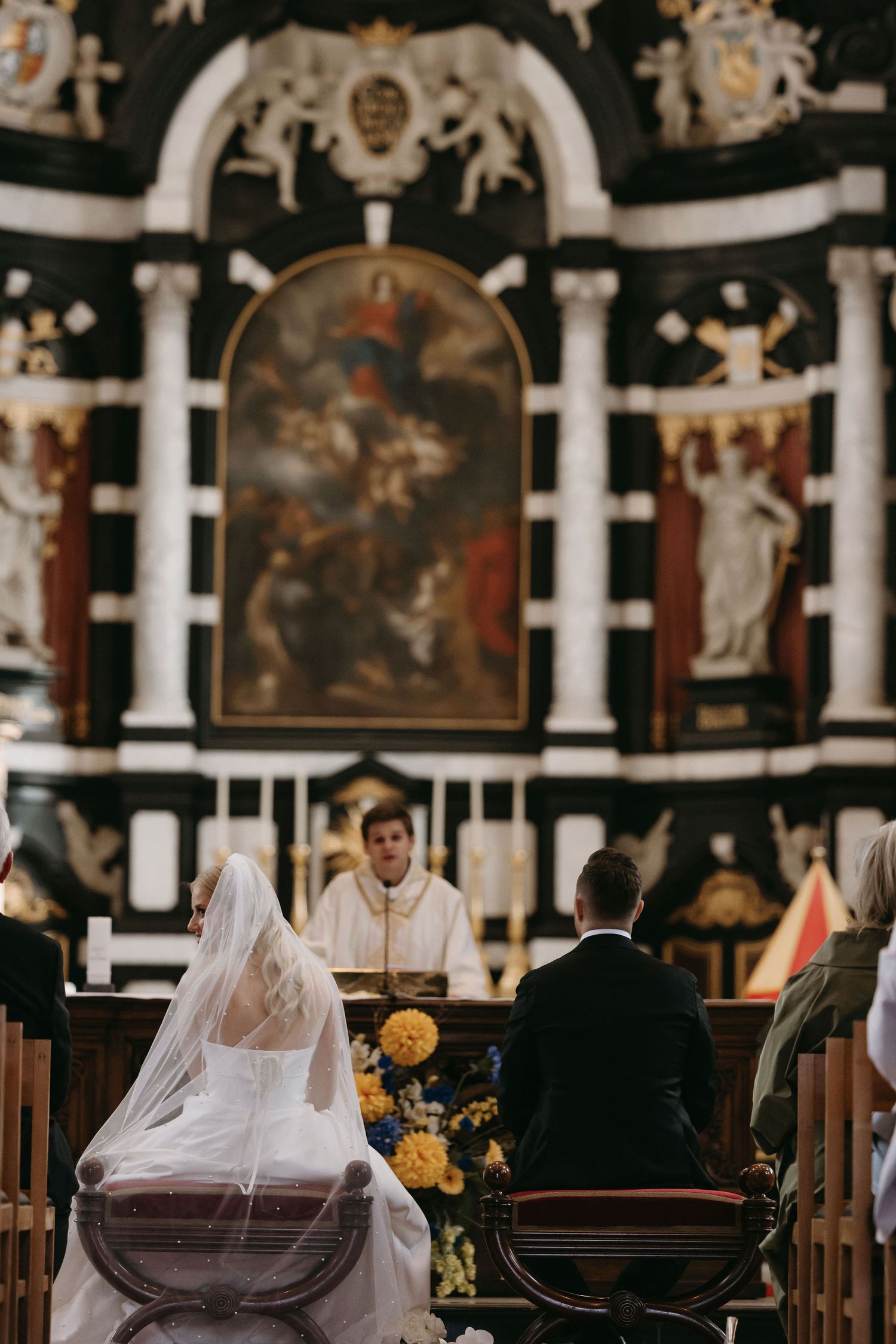 A traditional church wedding ceremony with ornate altar and religious artwork.