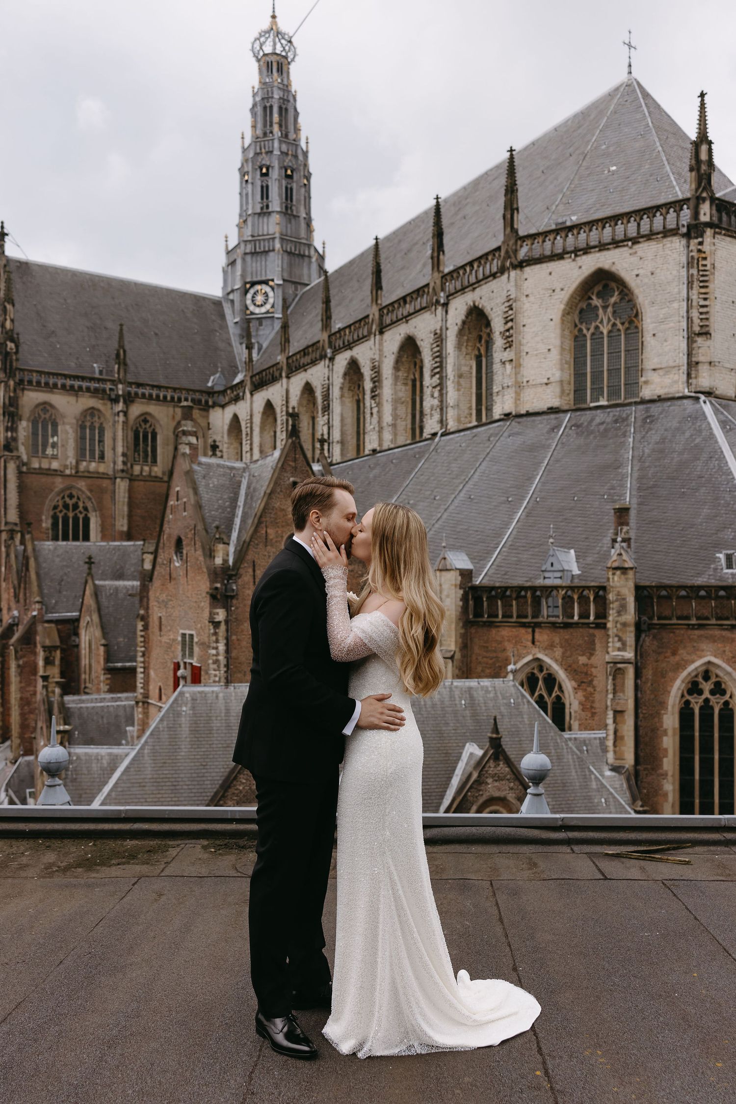 Wedding couple sharing a romantic moment in front of a stunning Gothic cathedral.