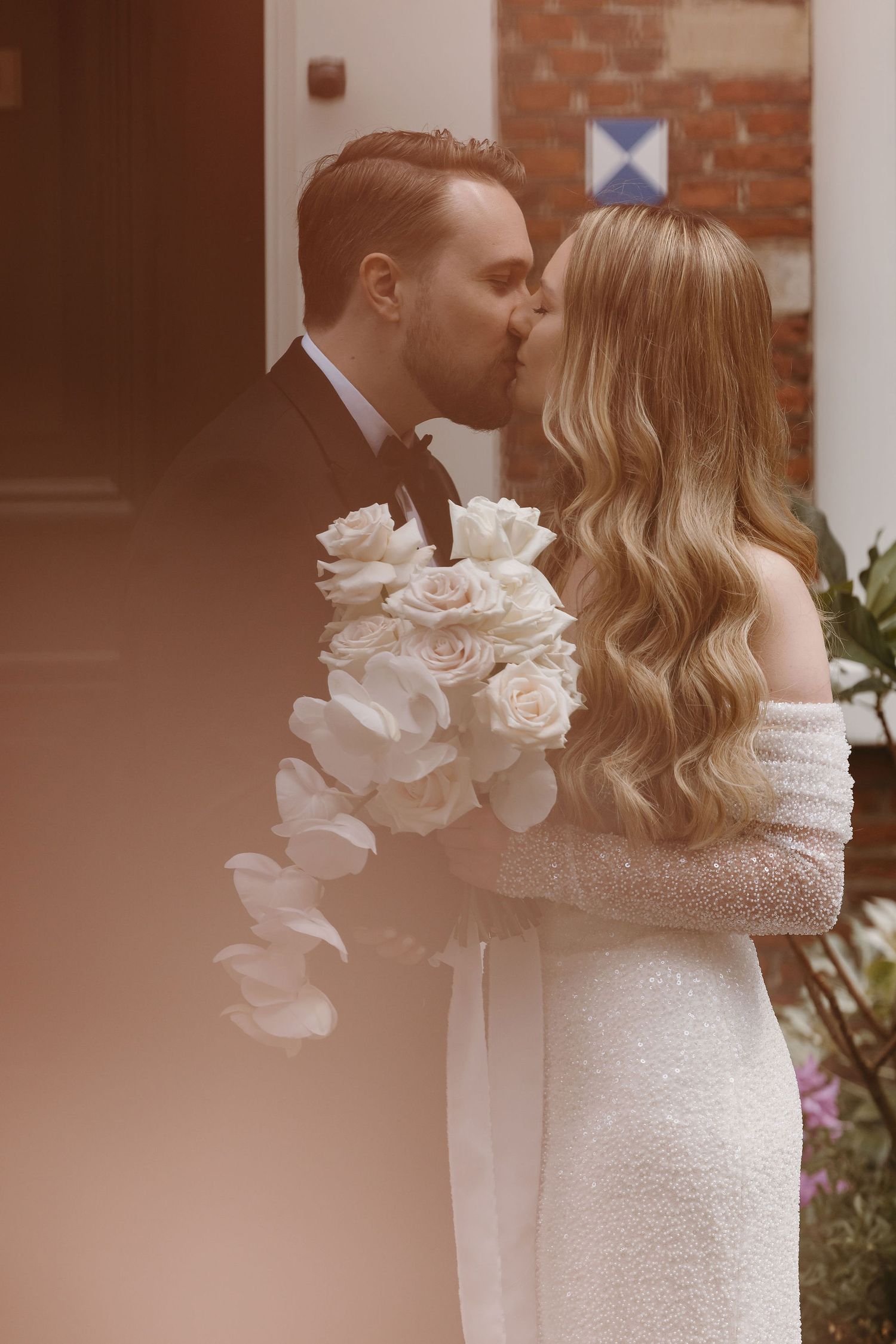 Romantic moment captured with white roses in foreground.
