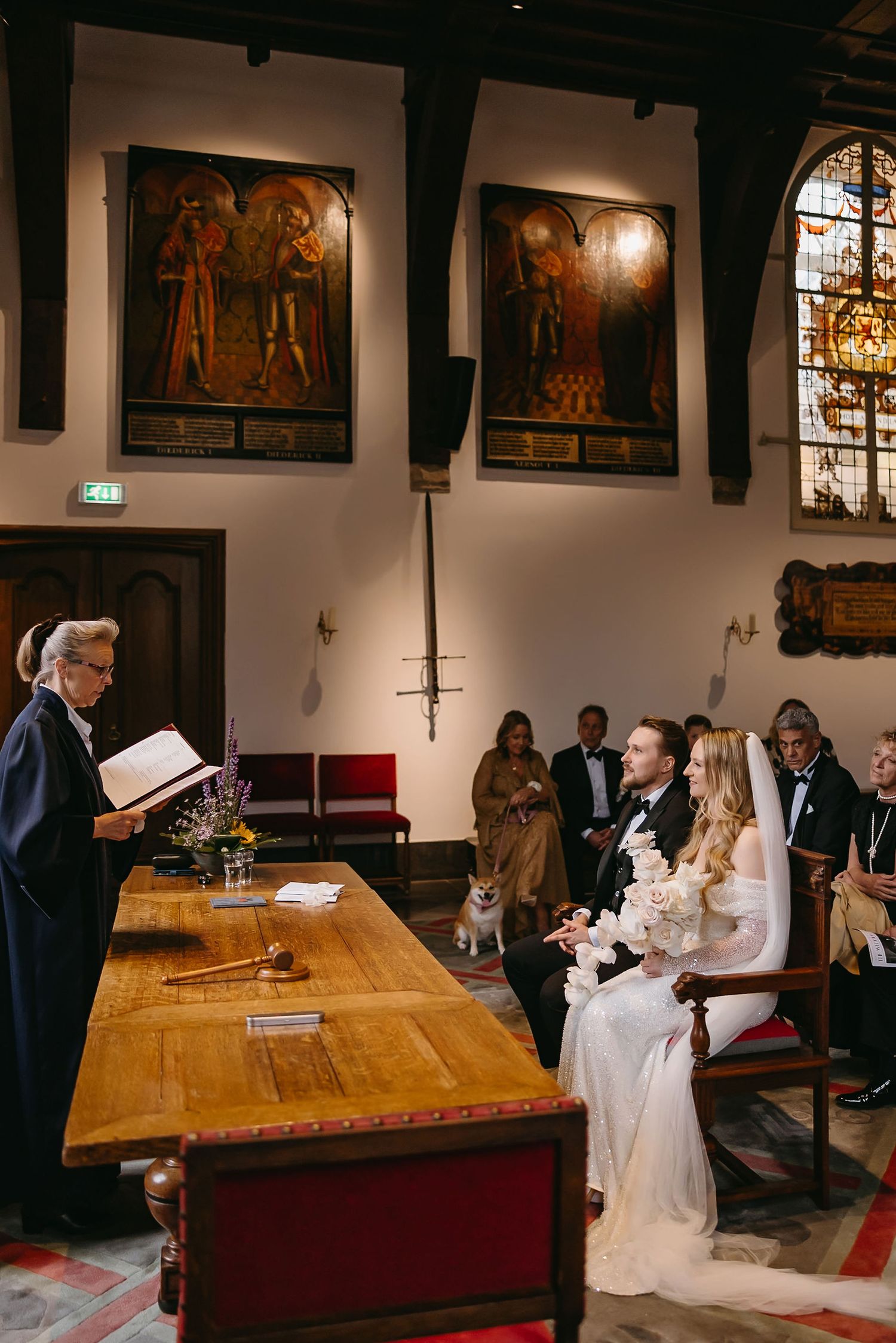Wedding ceremony in historic church interior with religious artwork and wooden furnishings.