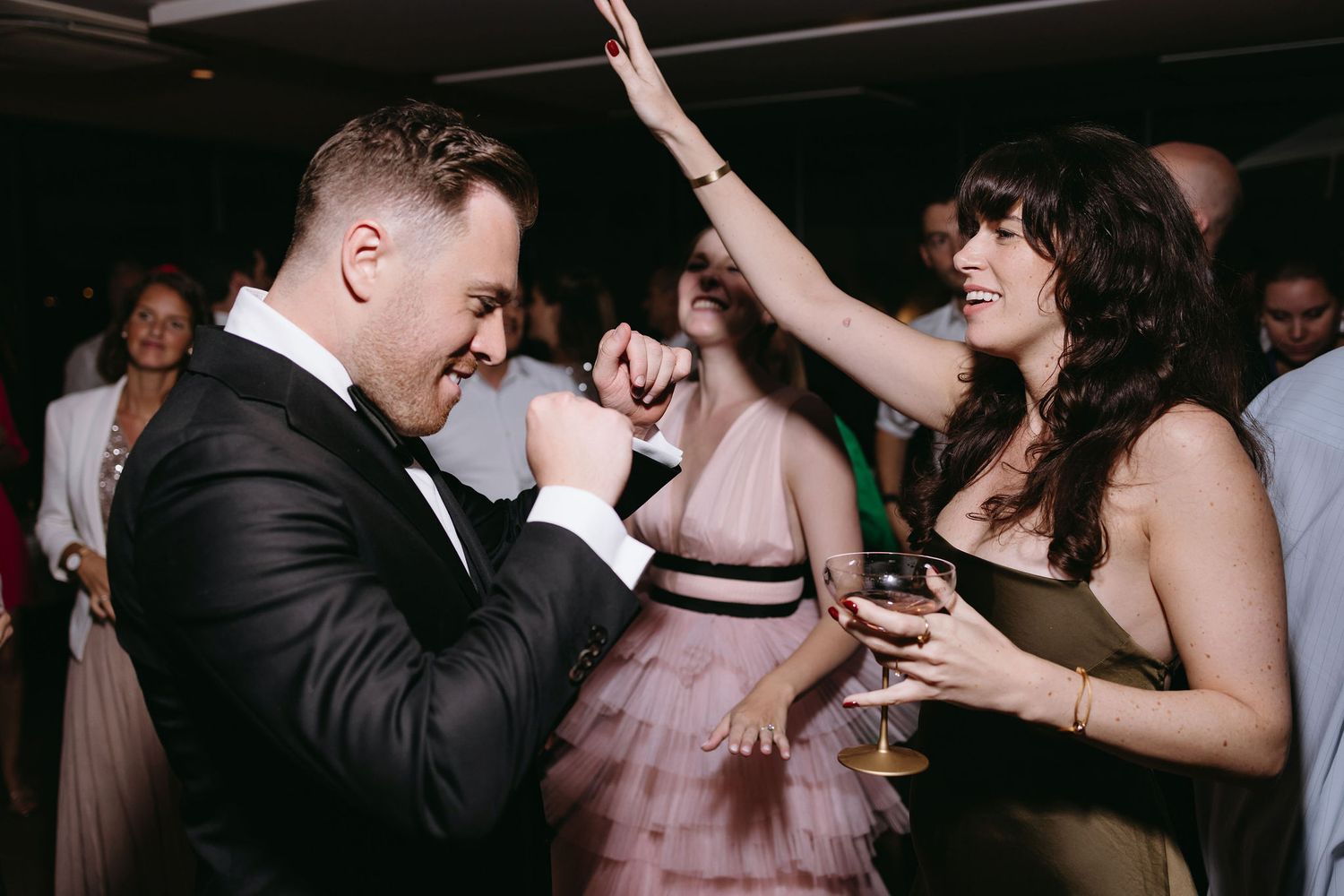Wedding reception dance floor scene with guests celebrating and dancing.