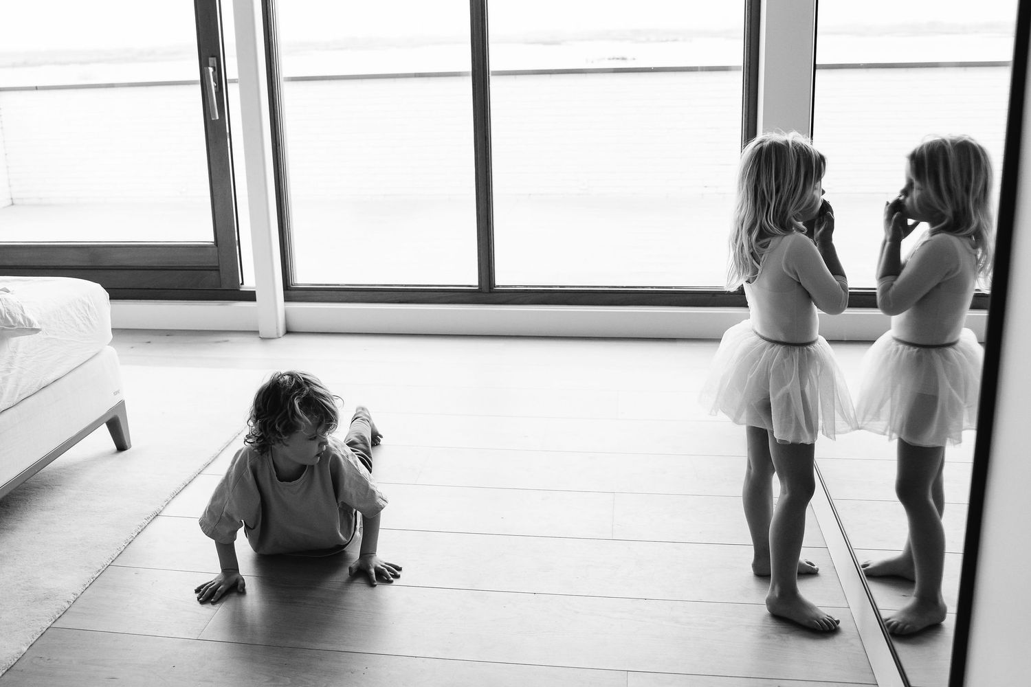 Minimalist black and white photos showing movement and interaction by a bright window.