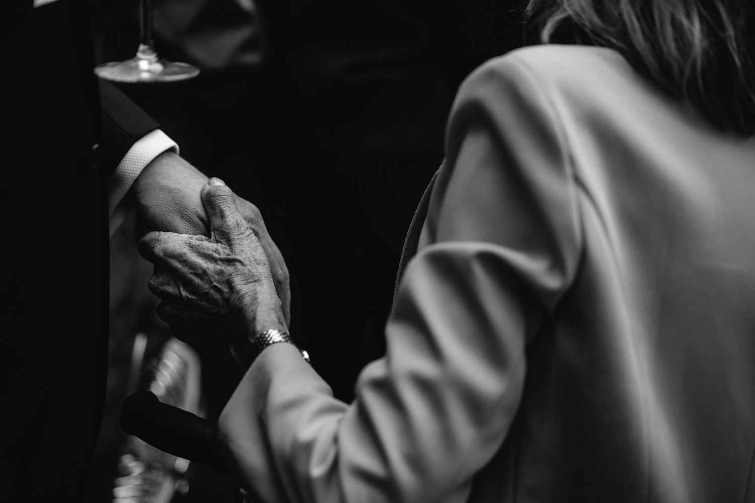 Black and white closeup of two people's hands touching during an intimate moment.