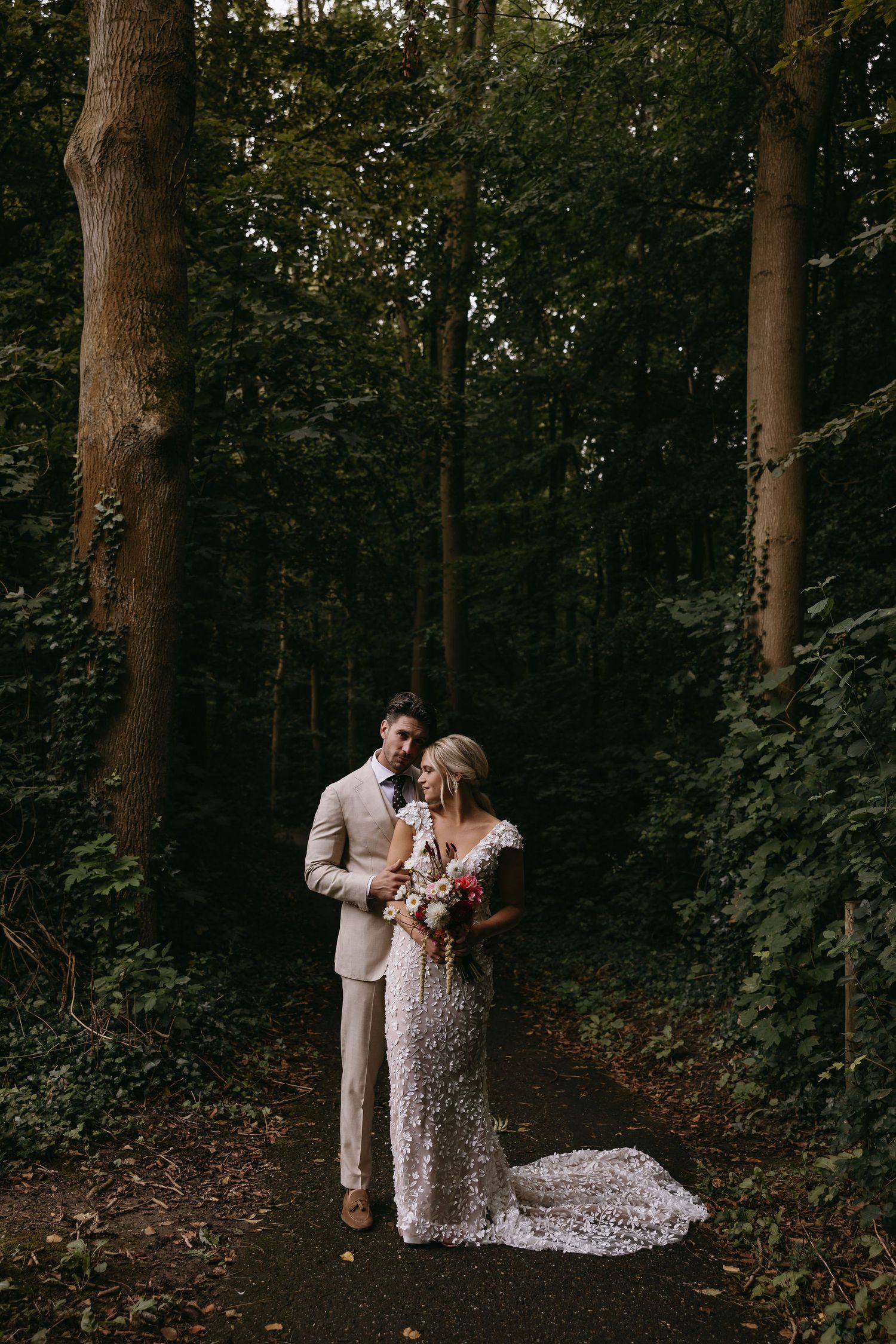 Couple sharing an intimate moment in a wooded forest setting.