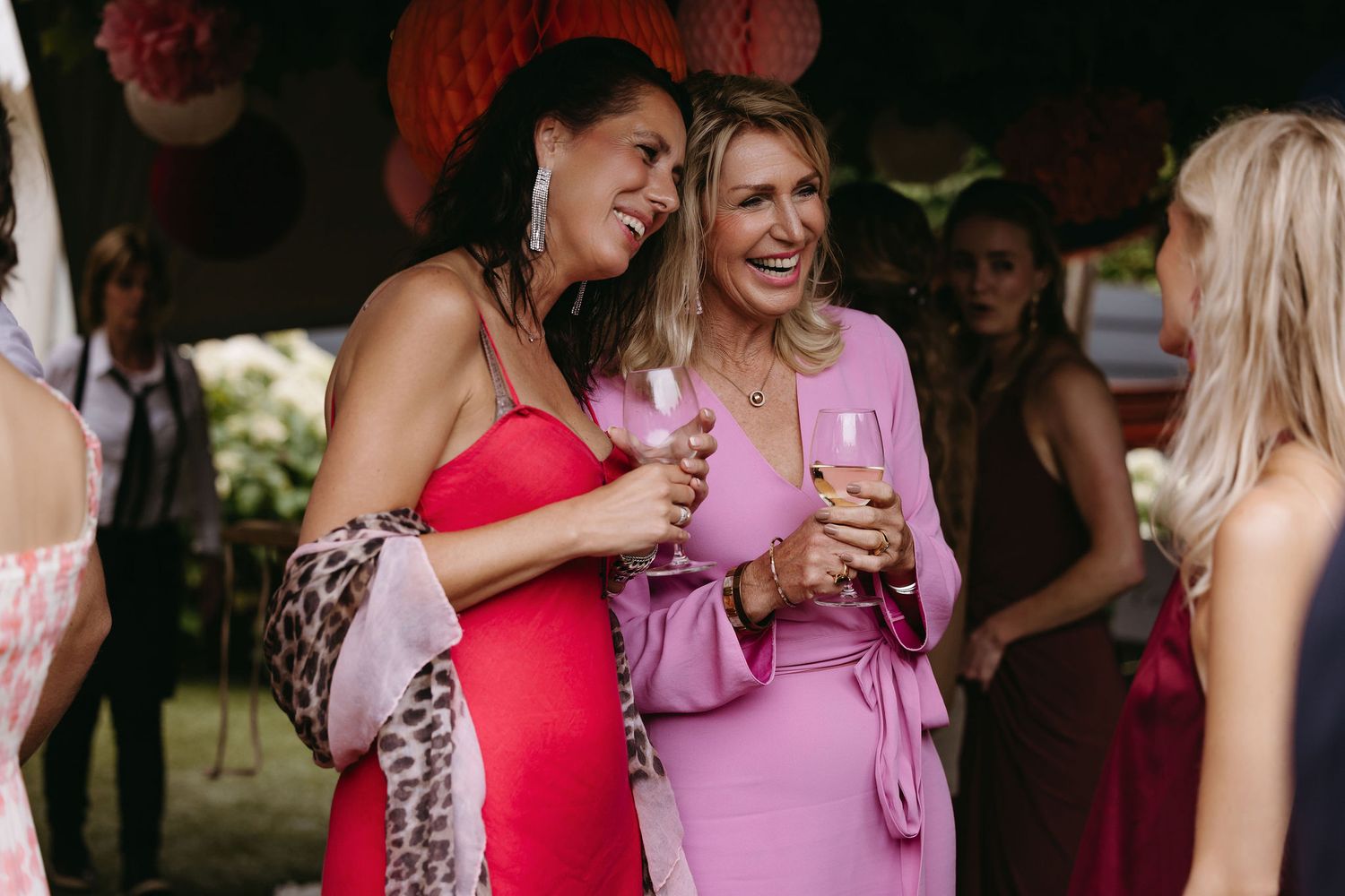 Celebrating guests gather around a backyard pool during a wedding reception.