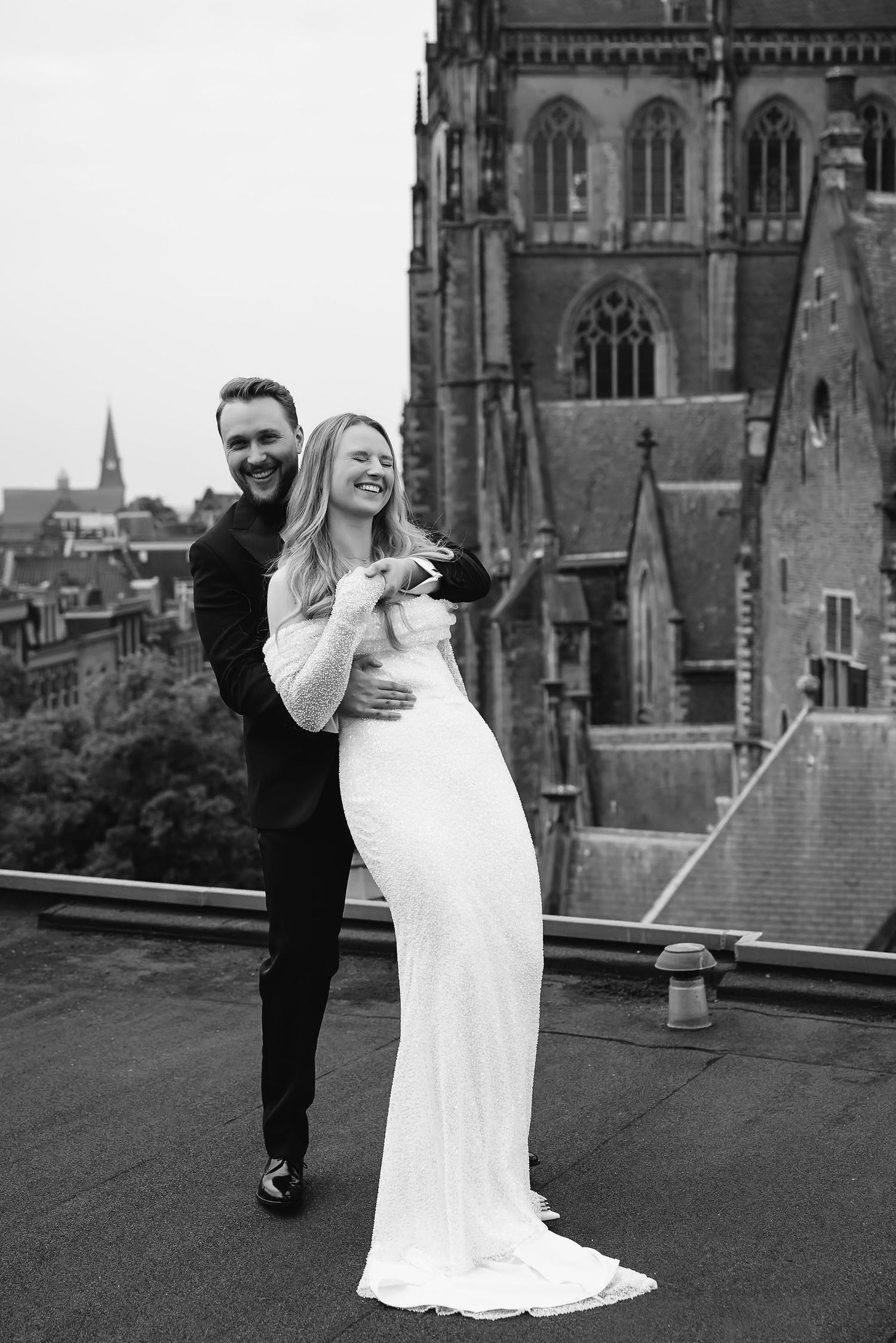 Dancing together on a rooftop with gothic cathedral architecture in the background.