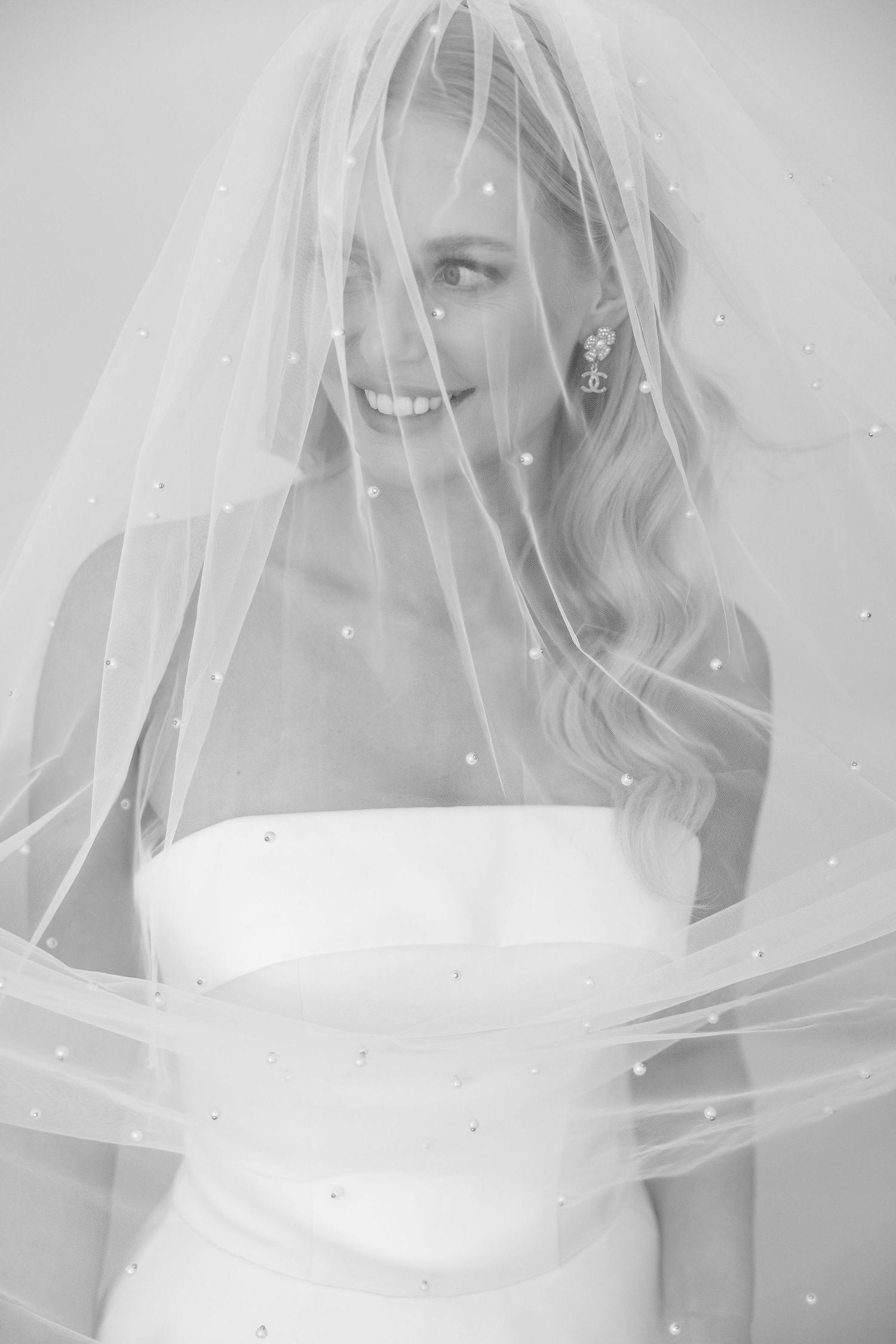 A bridal portrait showing a classic white veil and off-shoulder wedding dress.