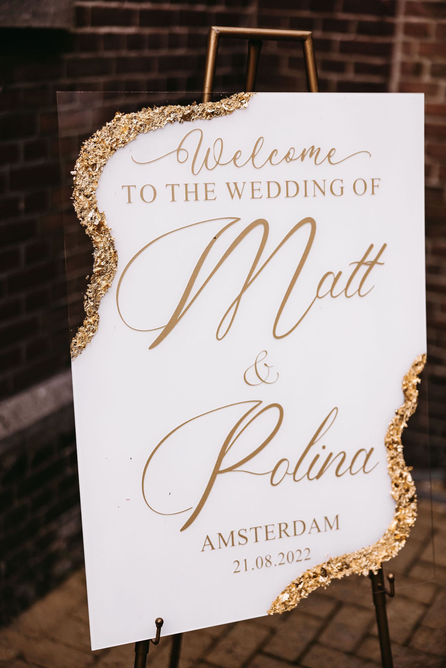 Elegant wedding welcome sign with gold accents and calligraphy on display.