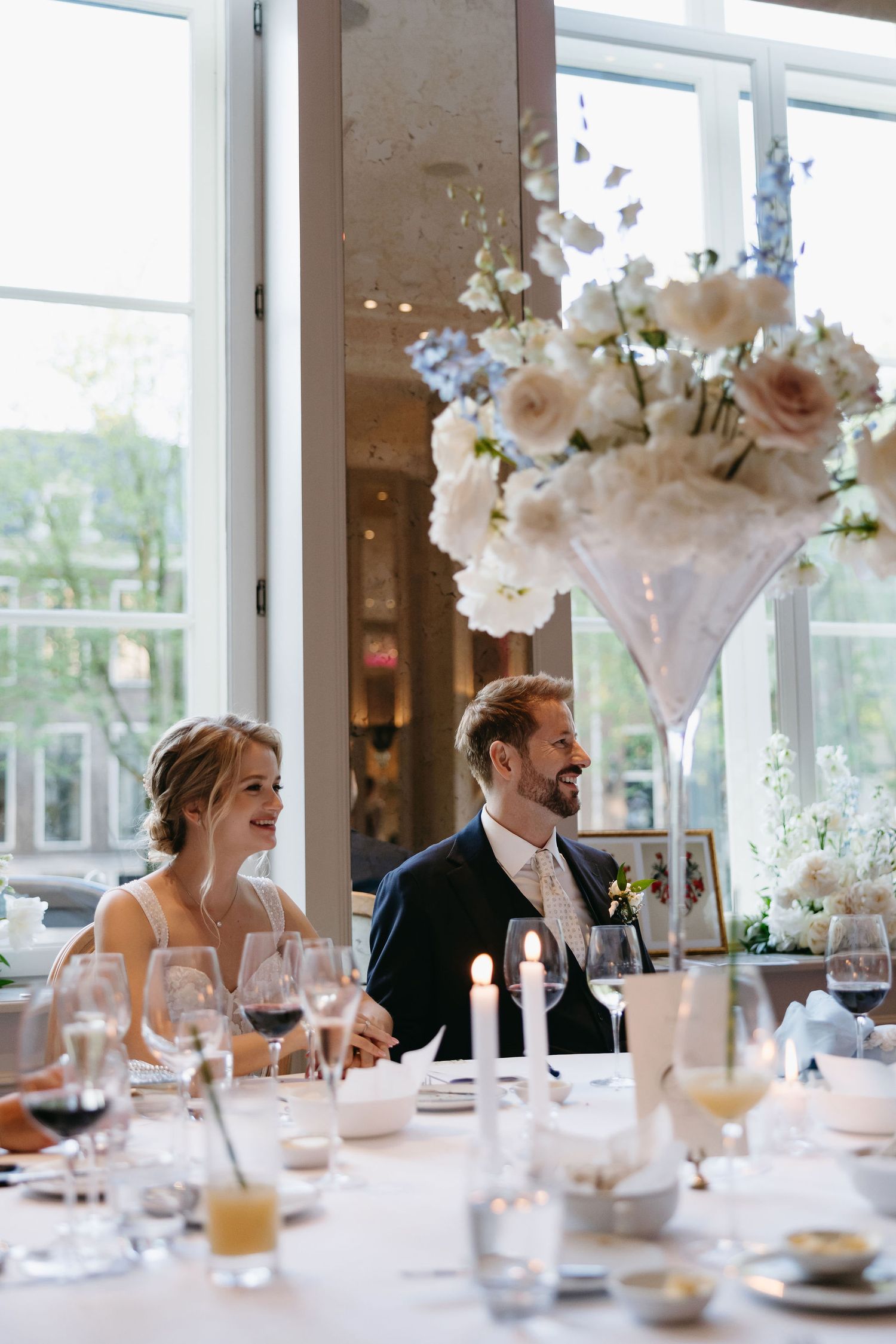 A candid reception moment with elegant floral centerpieces and table settings.