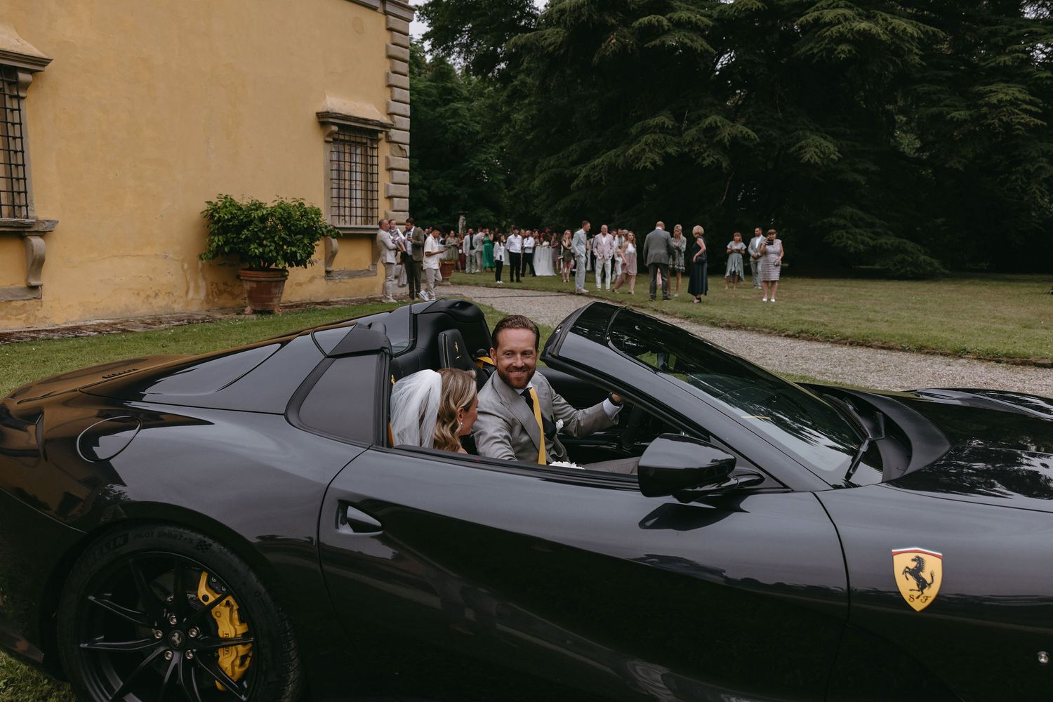 Grey Ferrari convertible parked outside an Italian villa.
