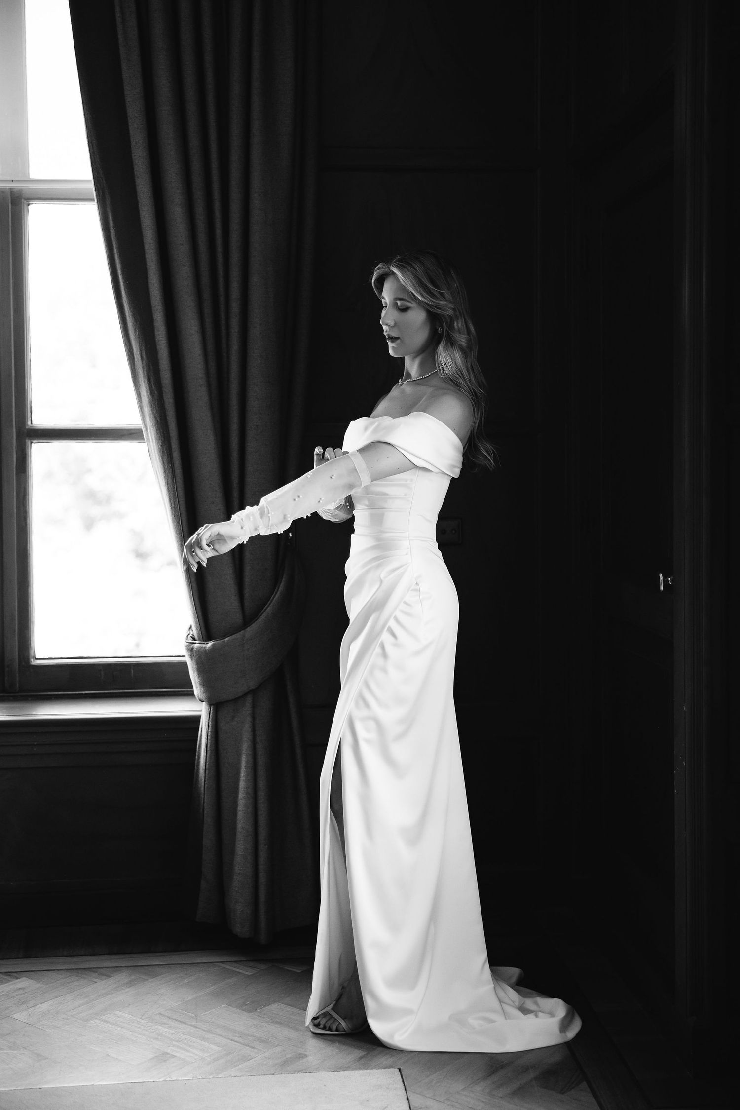 An elegant series of black and white photos showing movement as someone in a flowing white dress dances near a window.