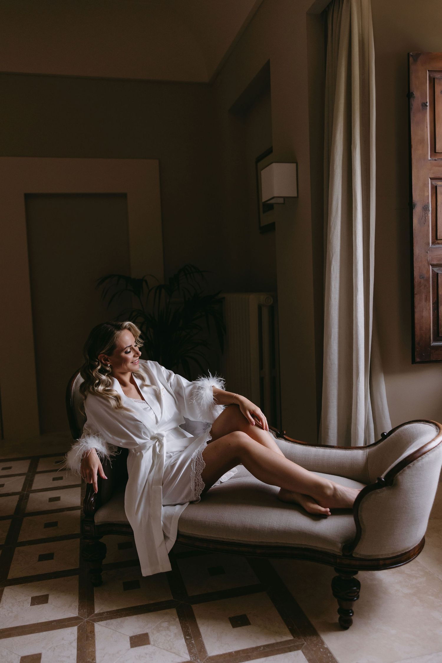 Artistic boudoir photography in black and white featuring elegant furniture and lighting.