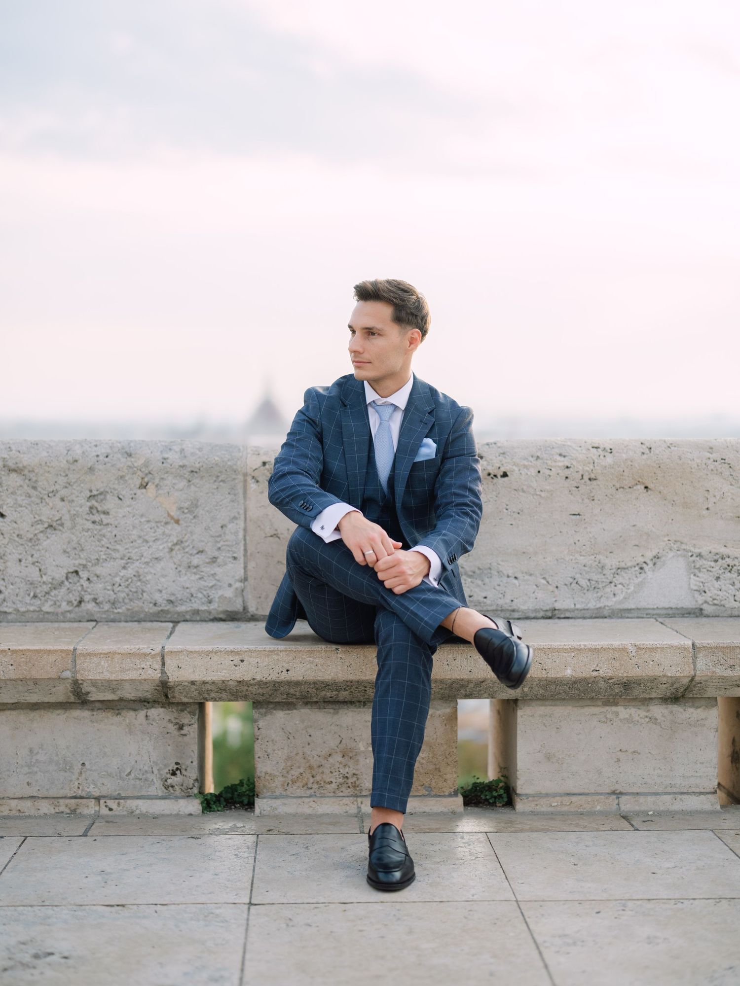 Captivating groom posing at sunrise on Fisherman’s Bastion in Budapest during a romantic pre-wedding session, captured by Hang Pham