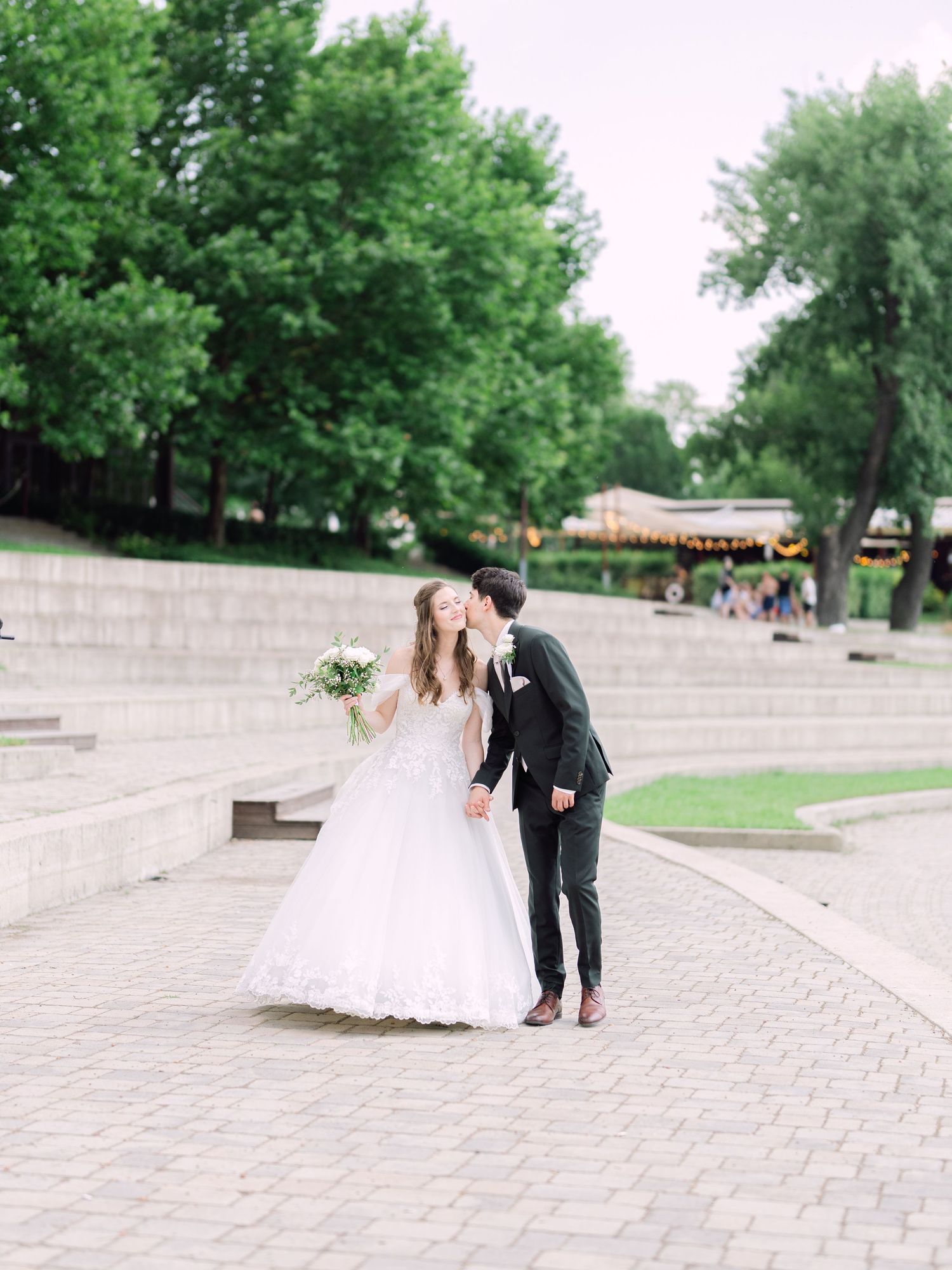 Cheerful couple posing at Kopaszi Gat in Budapest during a romantic pre-wedding session in natural light for an intimate Budapest wedding