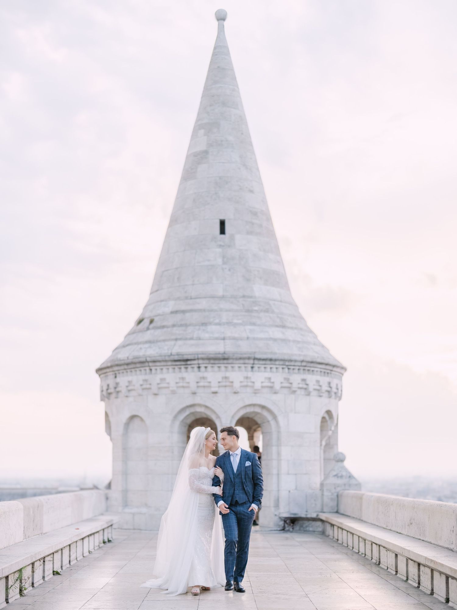 Captivating couple posing at sunrise on Fisherman’s Bastion in Budapest for a pre-wedding session, captured by Hang Pham Photography