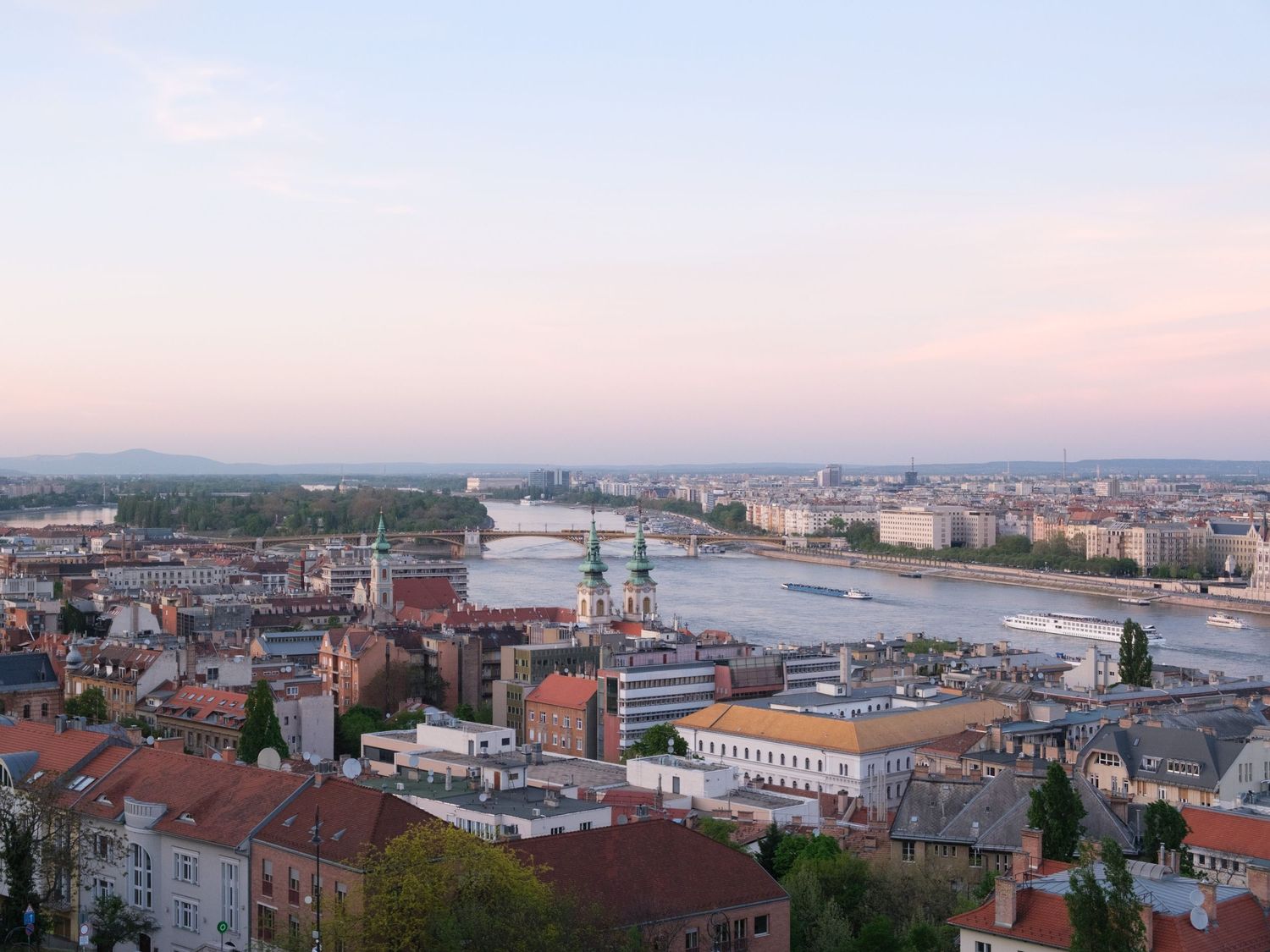 Stunning view of Budapest from Fisherman’s Bastion at sunset, showcasing the city’s iconic skyline bathed in golden hour light