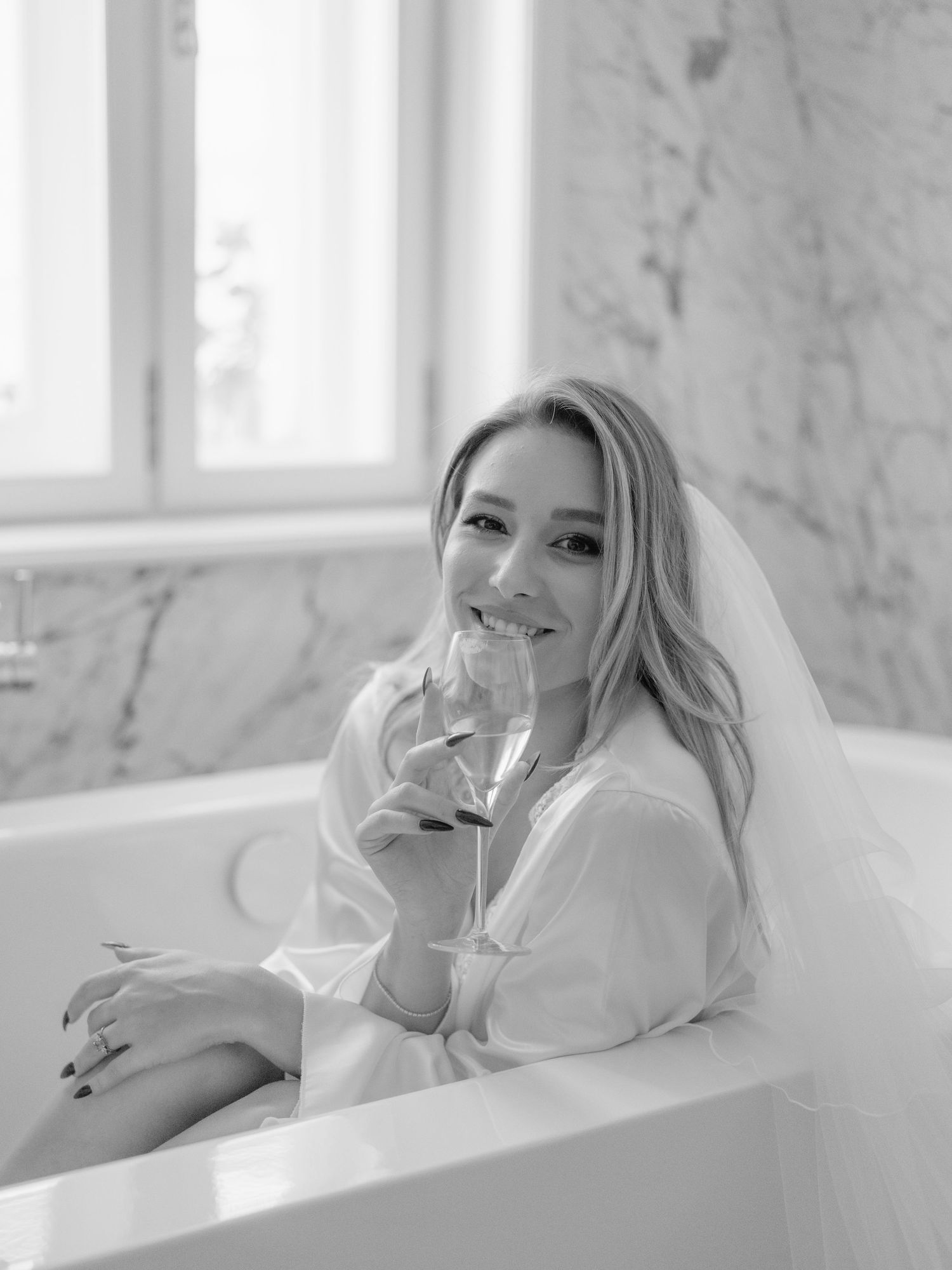 Wedding editorial at Matild Palace Budapest featuring a bride with champagne in a luxurious bathroom, captured in a flash shot