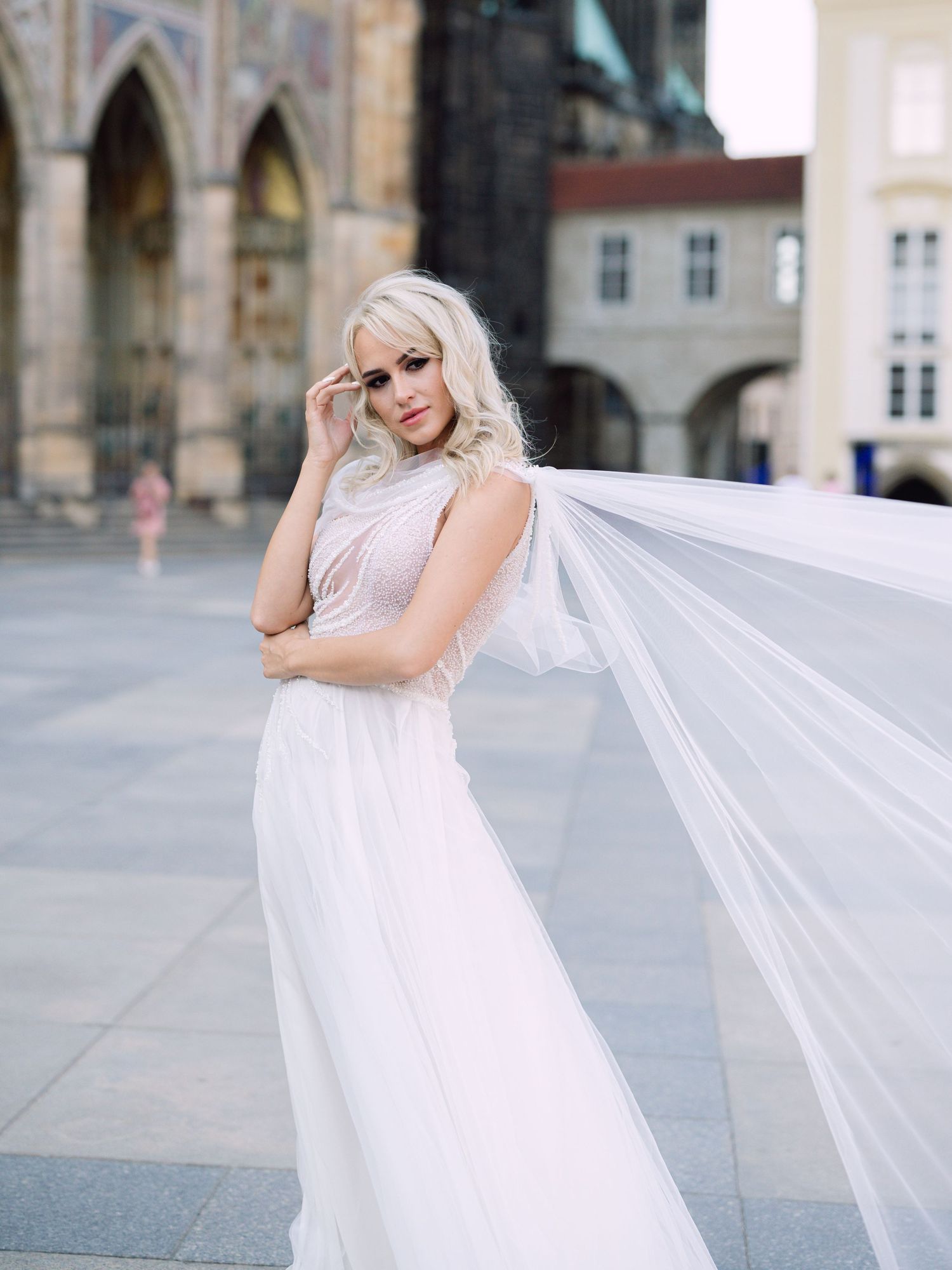 Dynamic bride in a Kozarics Viktor dress posing at Prague Castle for a destination wedding, beautifully captured by Hang Pham Photography