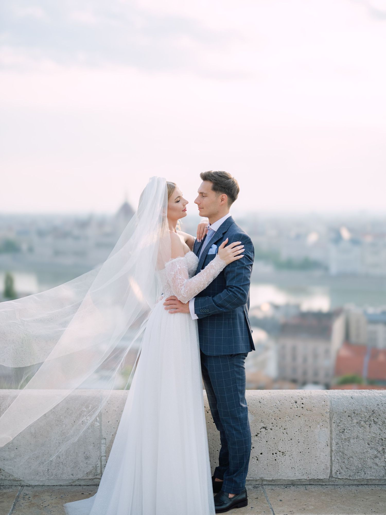 Captivating couple posing at sunrise on Fisherman’s Bastion in Budapest for a pre-wedding session, captured by Hang Pham Photography