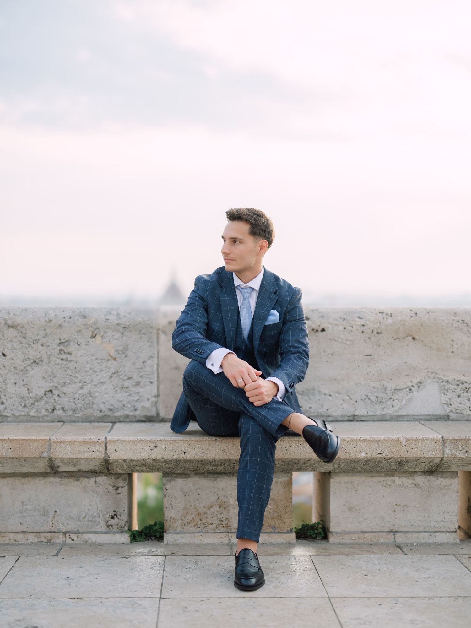 Captivating groom posing at sunrise on Fisherman’s Bastion in Budapest during a romantic pre-wedding session, captured by Hang Pham