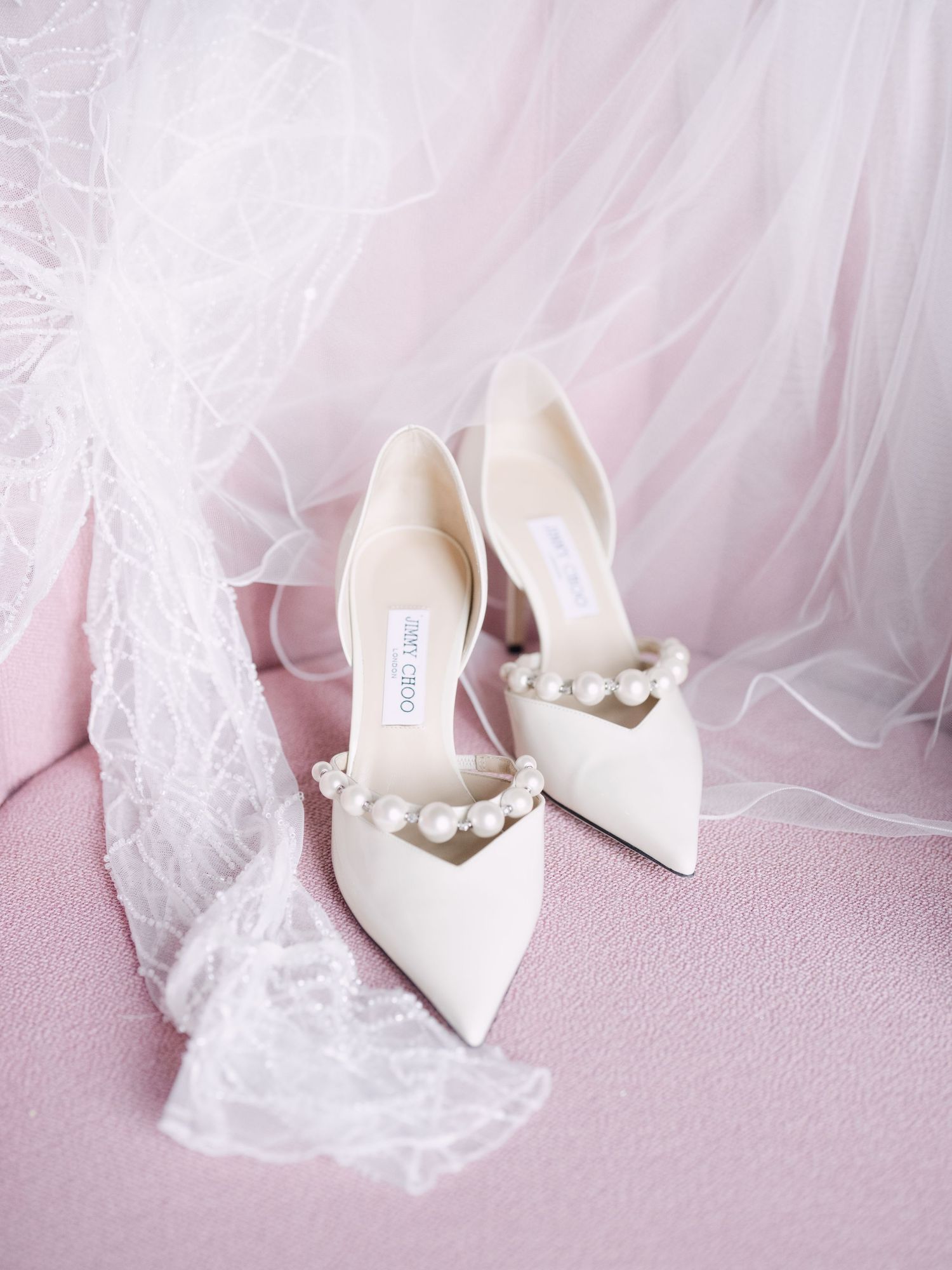 Wedding flatlay featuring Jimmy Choo bridal shoes paired with bridal veil, styled for a luxury wedding detail shot