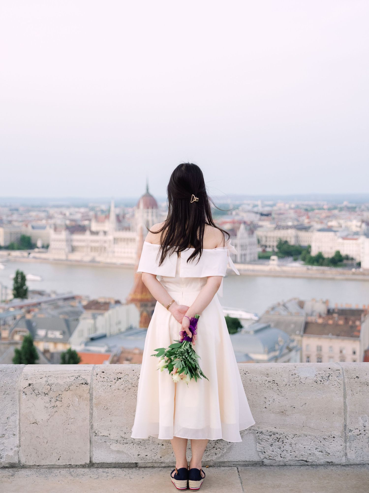 Charming bride posing during a scenic engagement shoot with breathtaking views of Budapest from Fisherman’s Bastion at golden hour