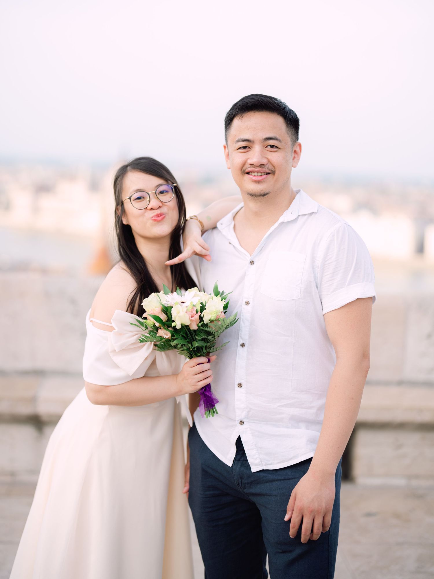 Charming couple posing during a scenic engagement shoot with breathtaking views of Budapest from Fisherman’s Bastion at golden hour
