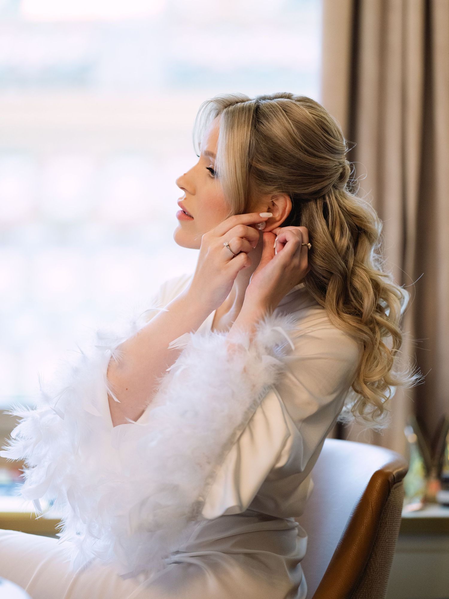 Captivating bride getting ready in a luxurious Hilton Hotel suite in Budapest, preparing for her wedding day with elegance and charm
