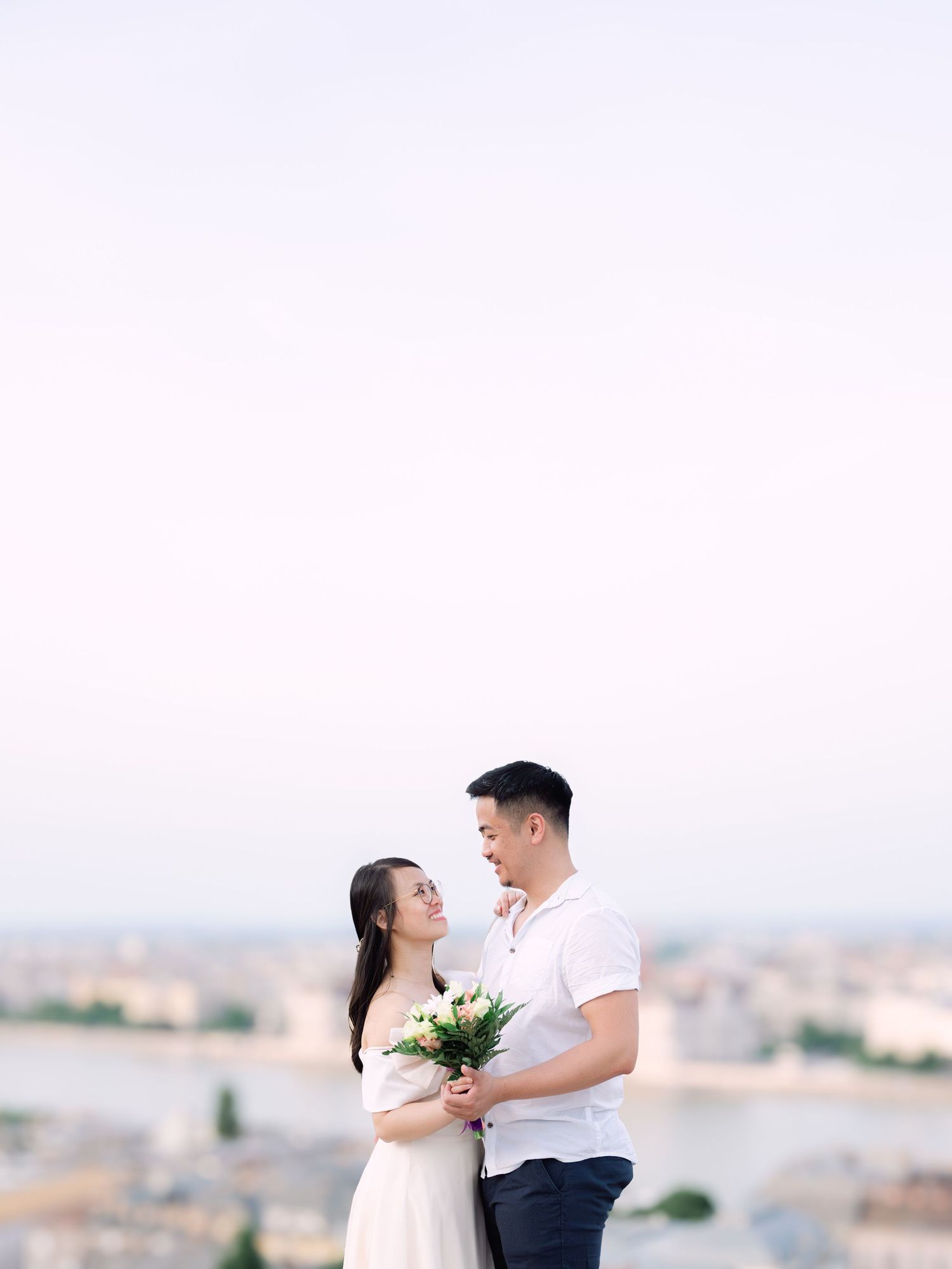 Charming couple posing during a scenic engagement shoot with breathtaking views of Budapest from Fisherman’s Bastion at golden hour