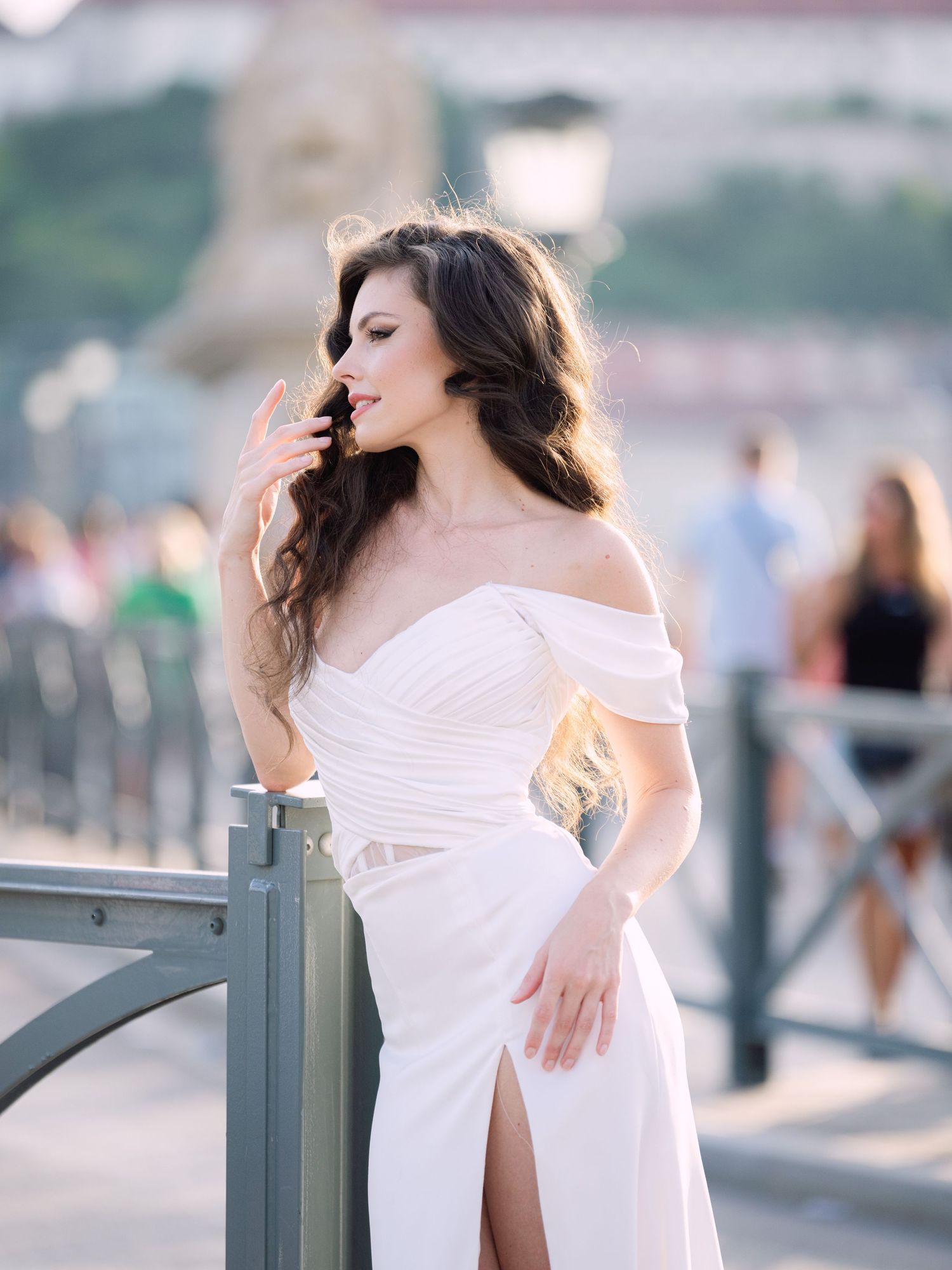 Elegant bride in a Leya Couture wedding dress posing on Budapest’s iconic Chain Bridge during a golden hour destination wedding editorial