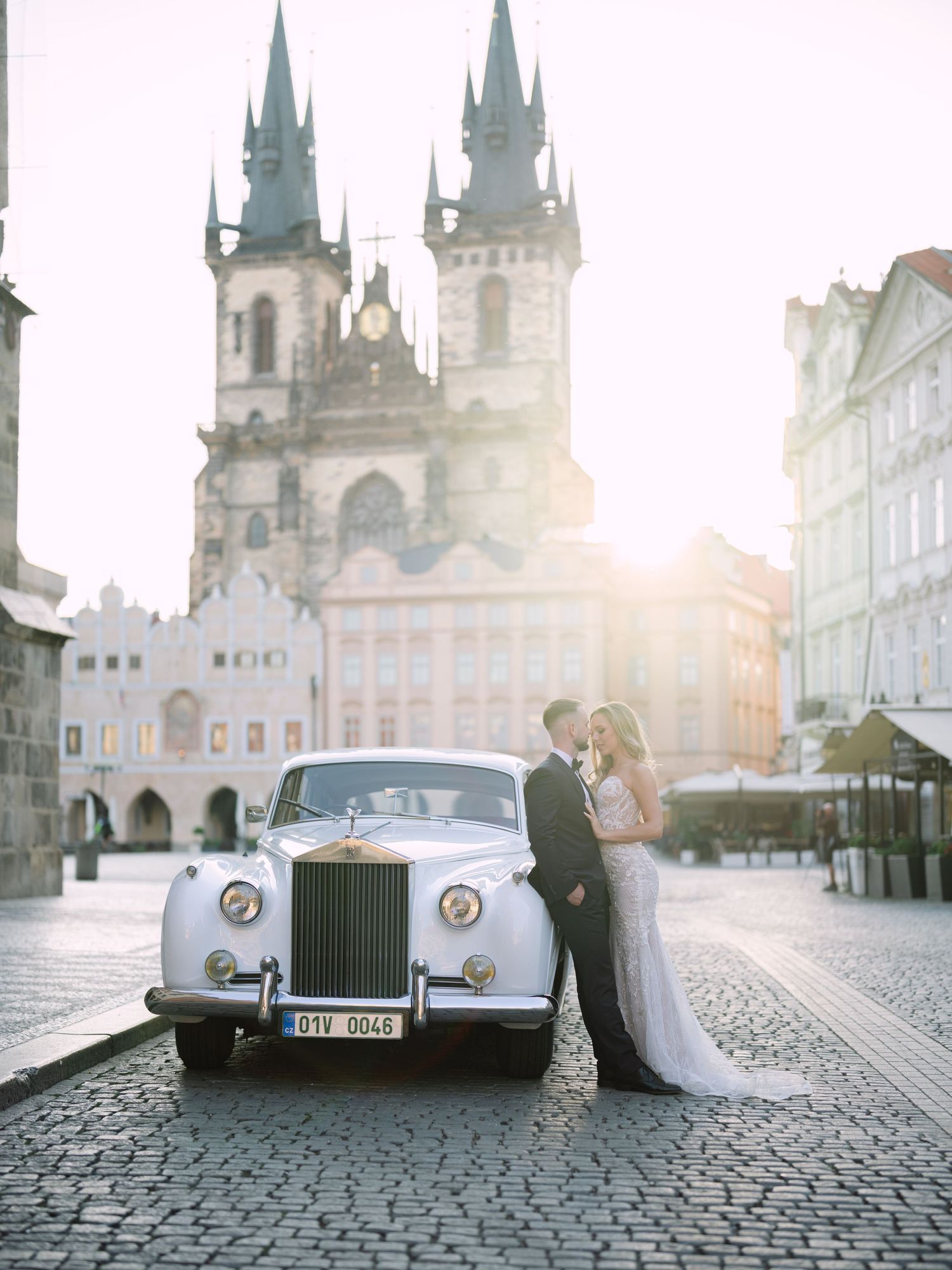 Elegant couple posing romantically in Old Town Square, Prague, during a destination elopement shoot, surrounded by historic architecture