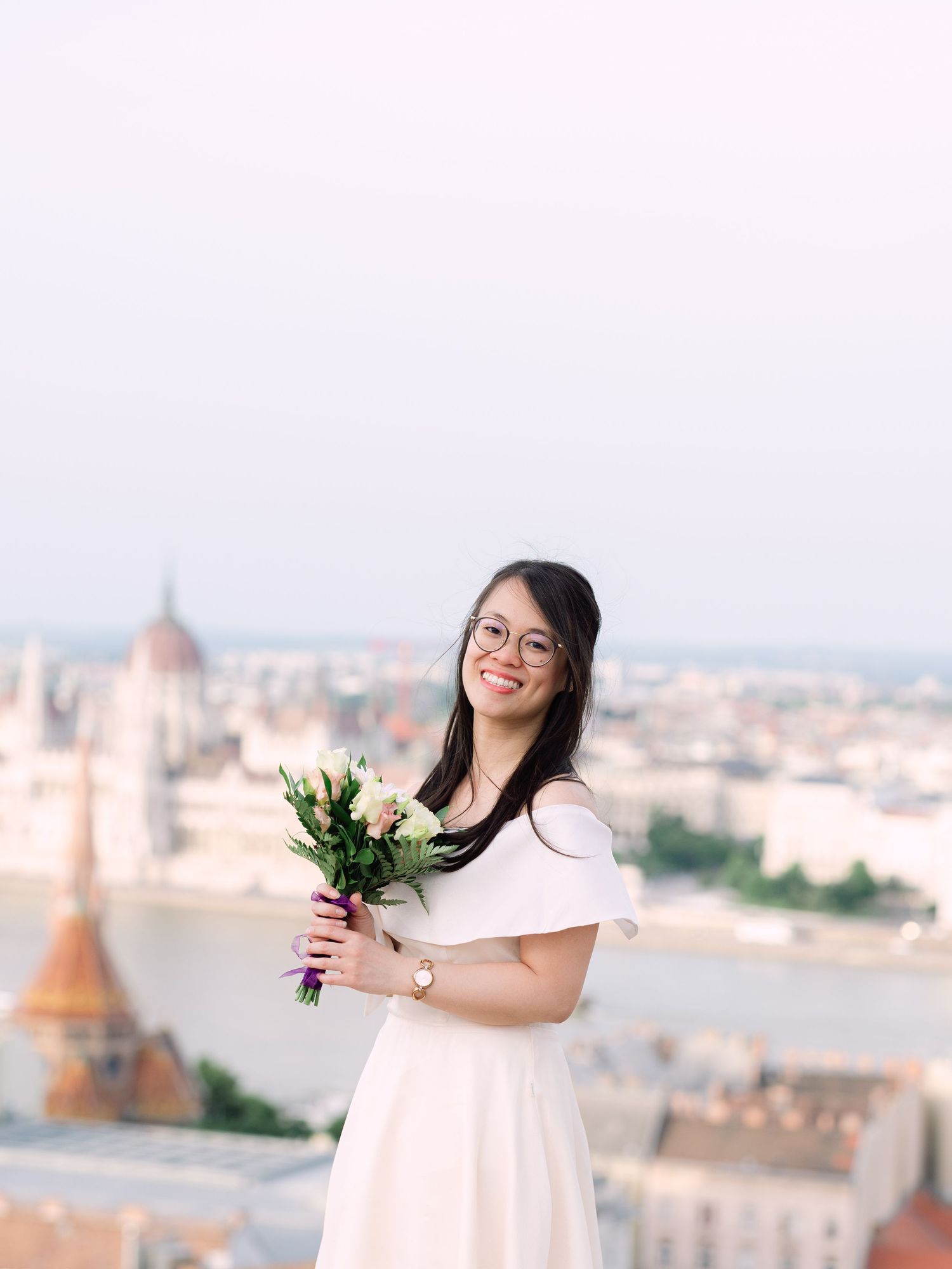 Charming bride posing during a scenic engagement shoot with breathtaking views of Budapest from Fisherman’s Bastion at golden hour