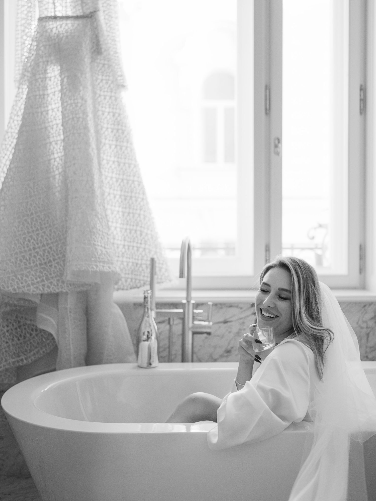 Wedding editorial at Matild Palace Budapest featuring a bride with champagne in a luxurious bathroom, captured in a flash shot