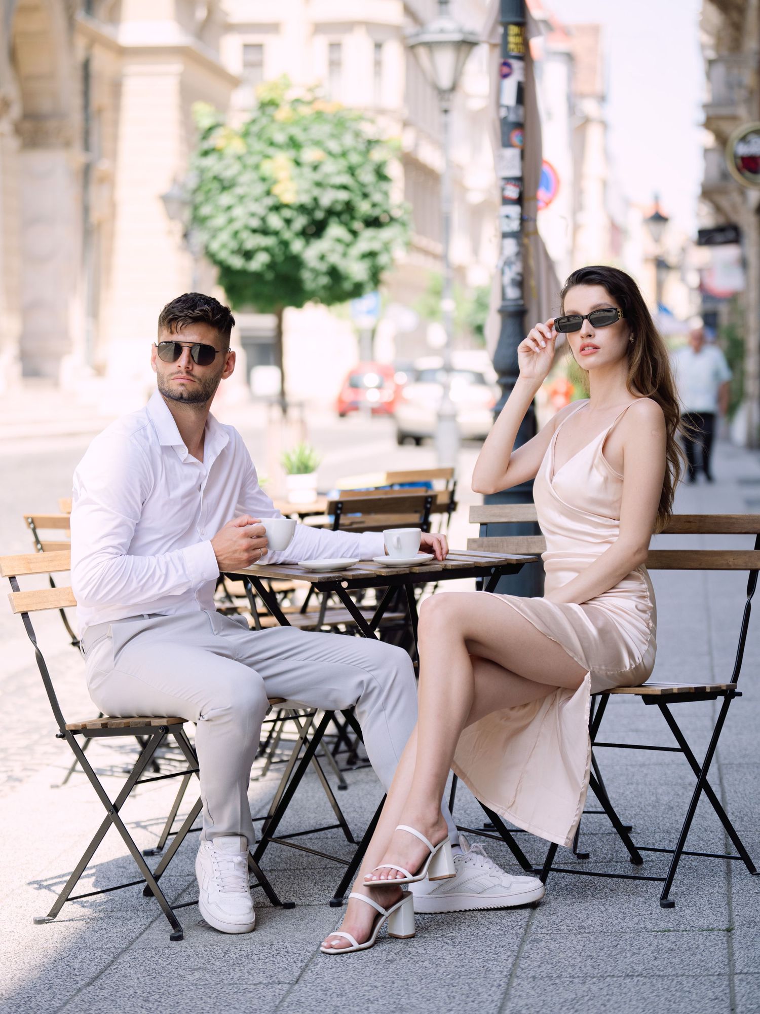 Dynamic couple posing stylishly on Andrássy Street in Budapest near the Louis Vuitton boutique during a chic portrait shoot by Hang Pham Pho